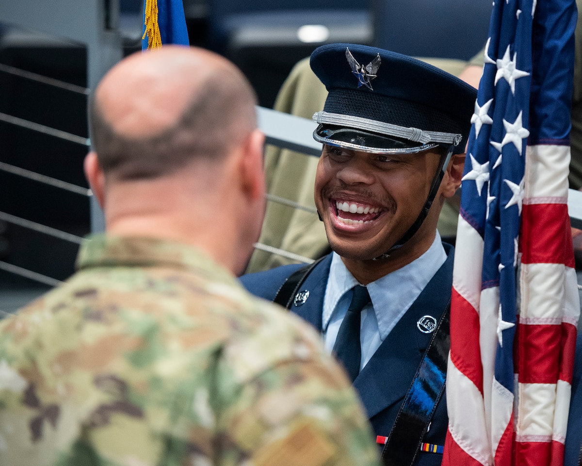Senior Airman McKinley Gillis, Wright-Patterson Air Force Base guardsman, laughs with Col. Patrick Miller, 88th Air Base Wing and Wright-Patterson Air Force Base commander, March 16, 2022, prior to the honor guard taking part in the opening ceremony of the NCAA men’s basketball tournament First Four game between Wright State and Bryant. The base was also represented in the opening ceremony by a group of Airmen unfurling a large American flag. (U.S. Air Force photo by R.J. Oriez)