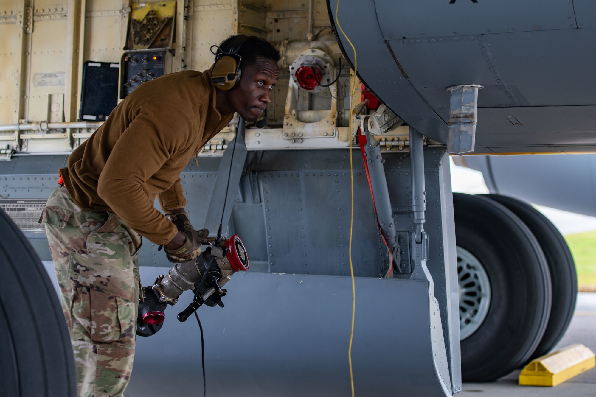 An Airman disconnects a fuel hose from a plane