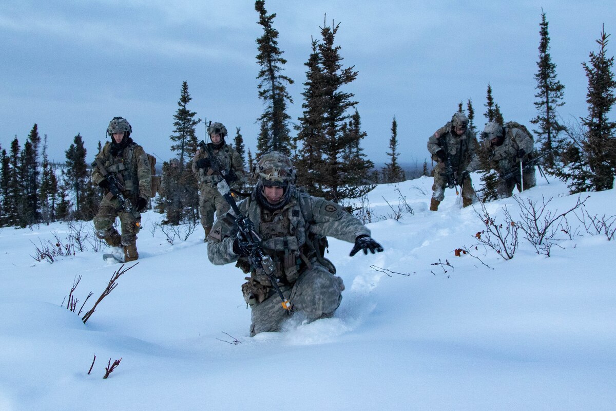 Soldiers wade through snow.