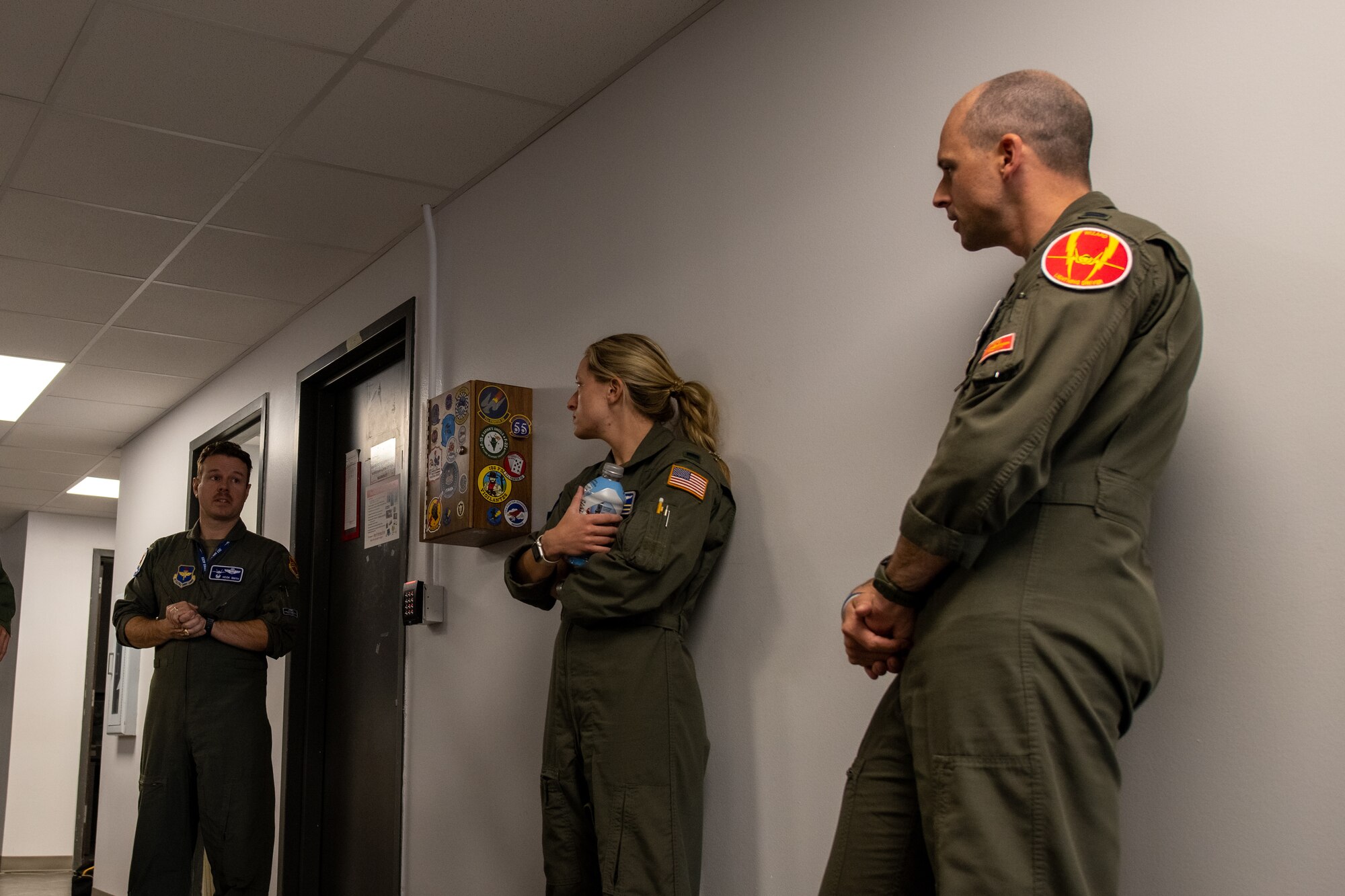 individuals stand in hallway