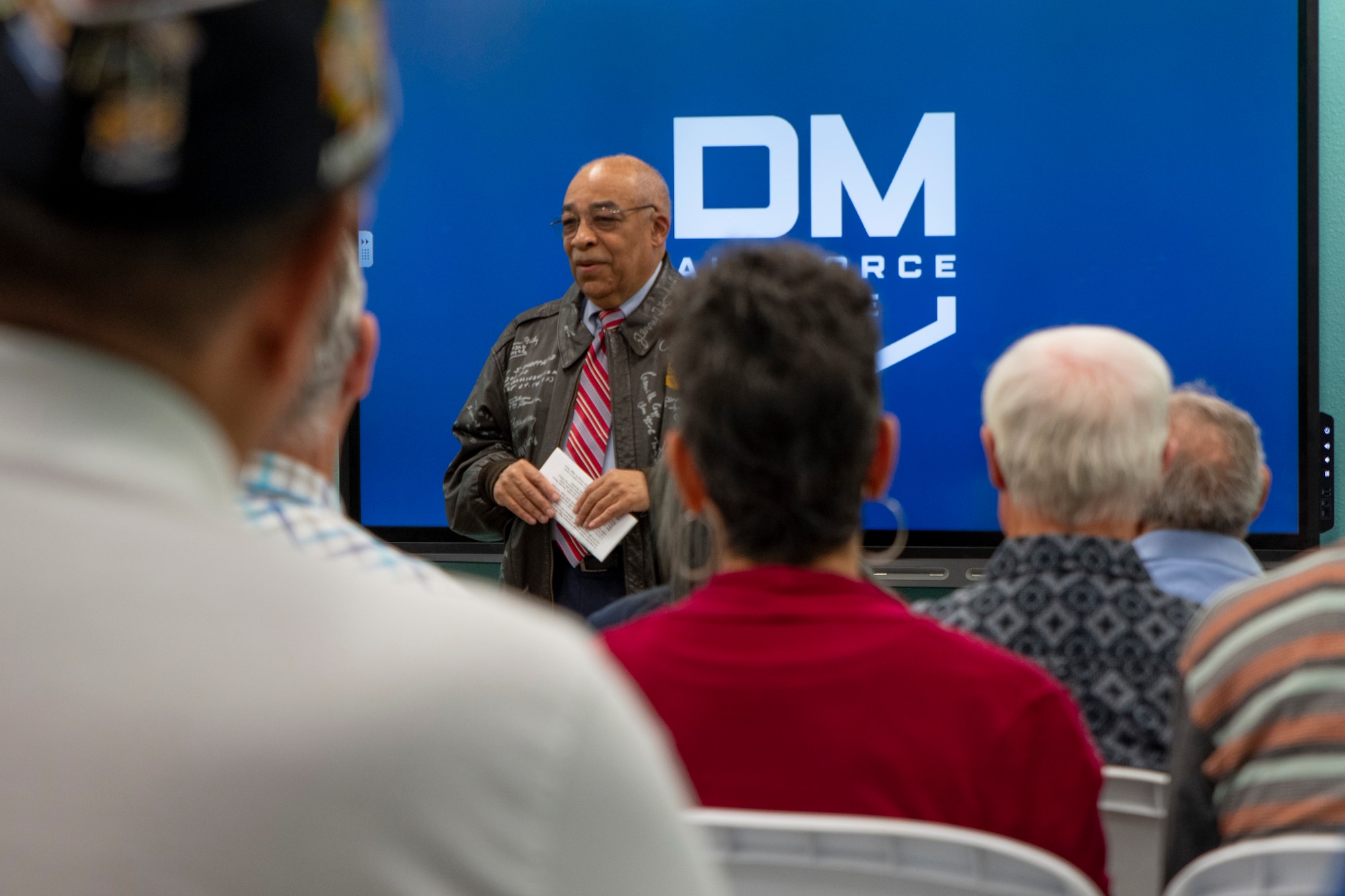 Man speaks to a group of people.