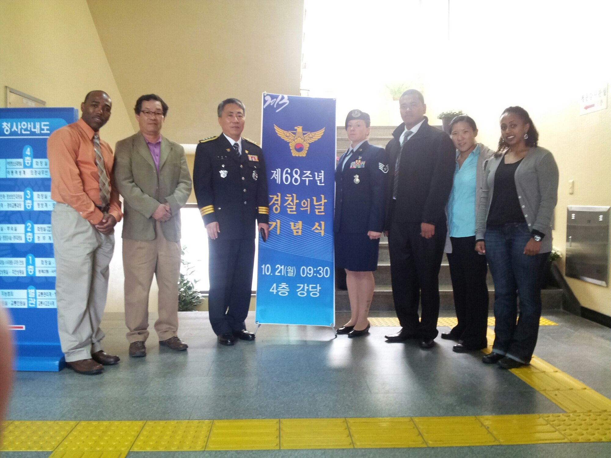 A civilian smiles with Airmen and local police officers.