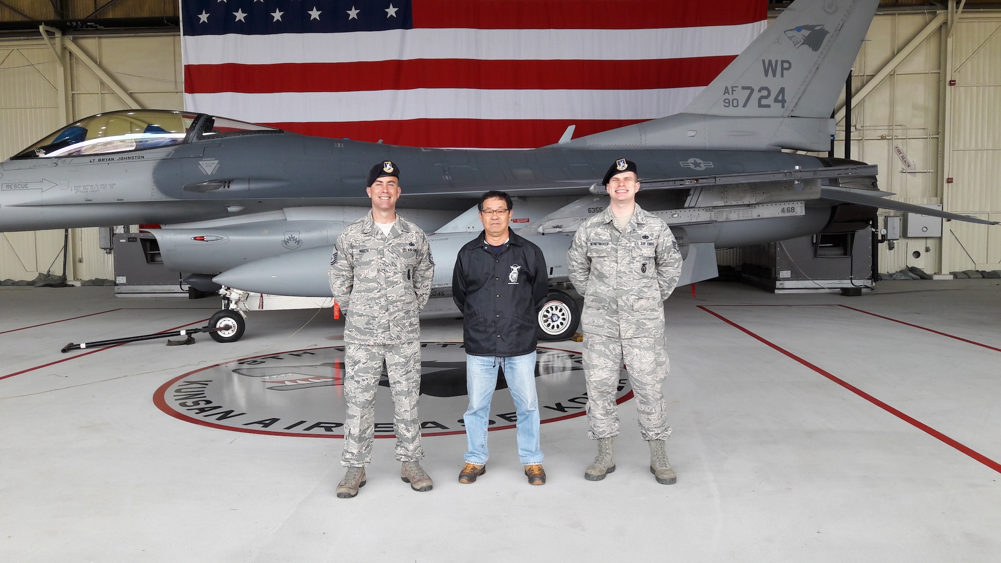 A civilian smiles with Airmen.