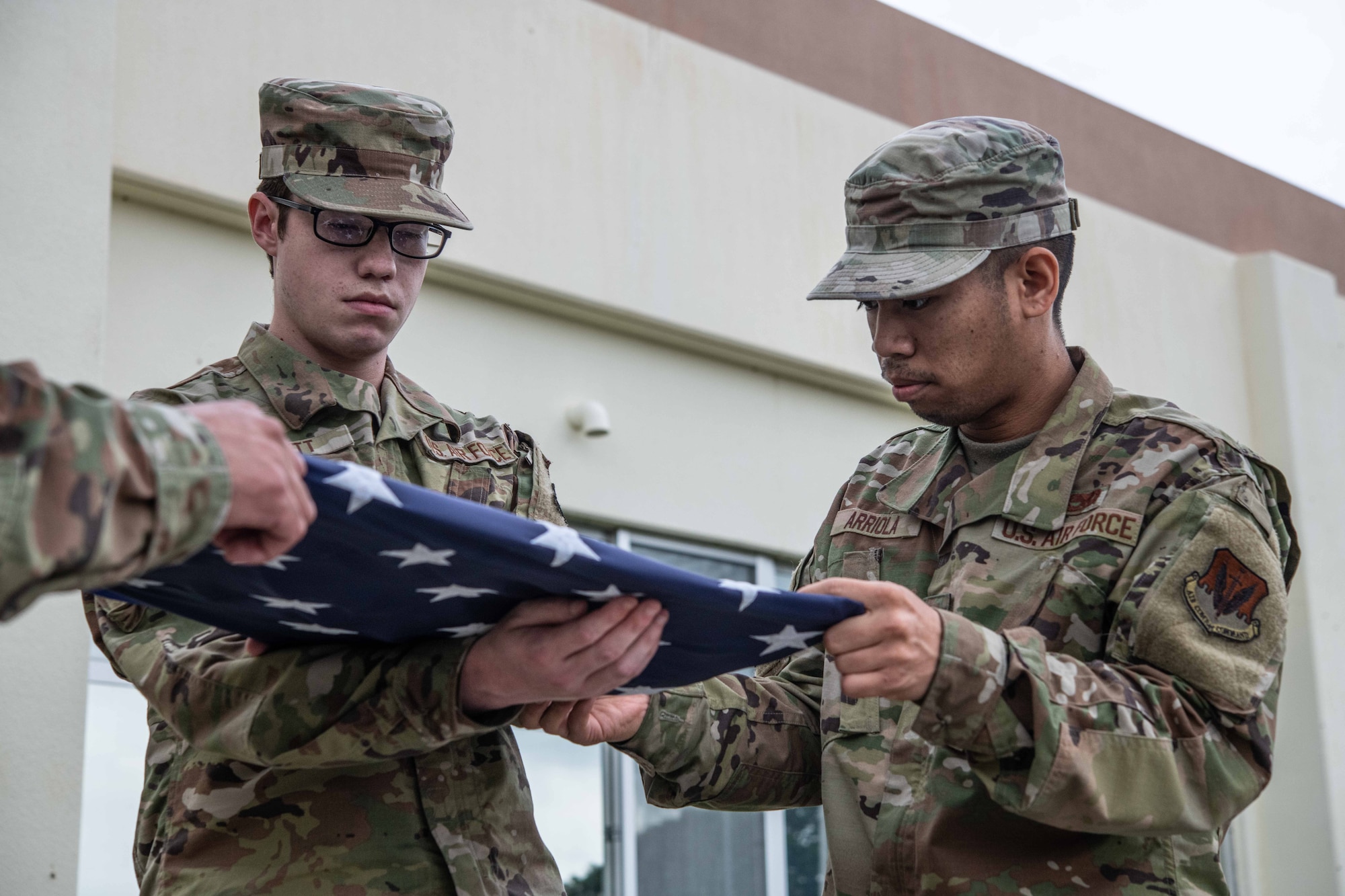 Airmen fold the U.S. flag.