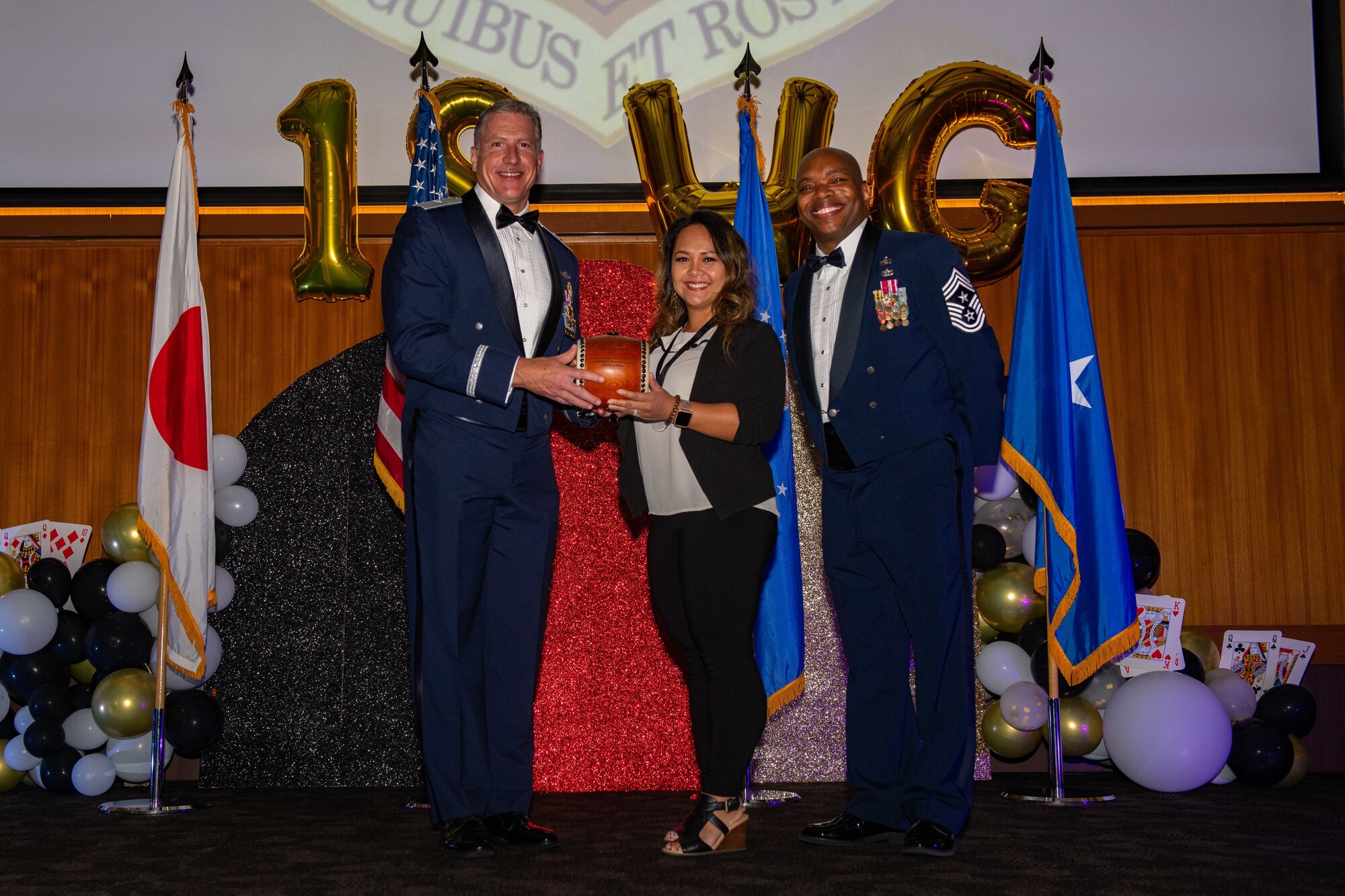 An award winner poses with a general and chief master sergeant at an awards ceremony