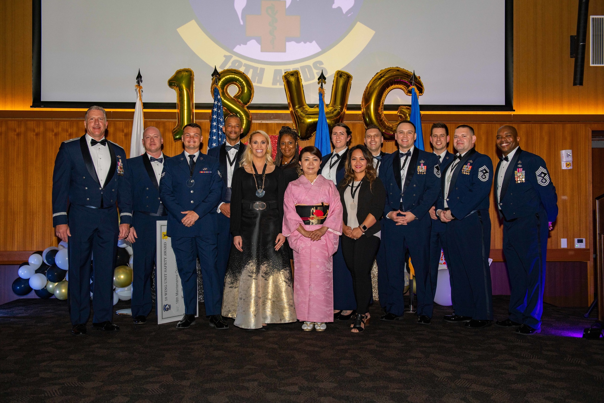 A group of award winners pose for pictures at a dinner banquet