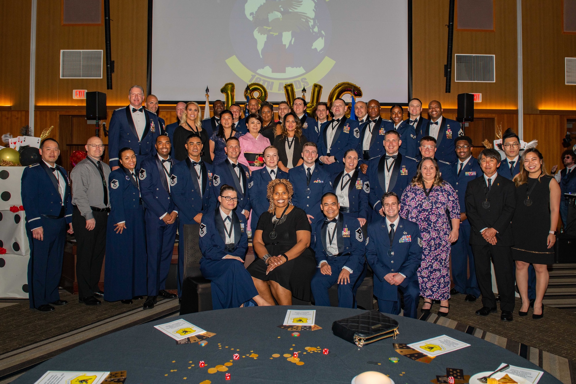 A bunch of award winners take a group photo at a awards dinner