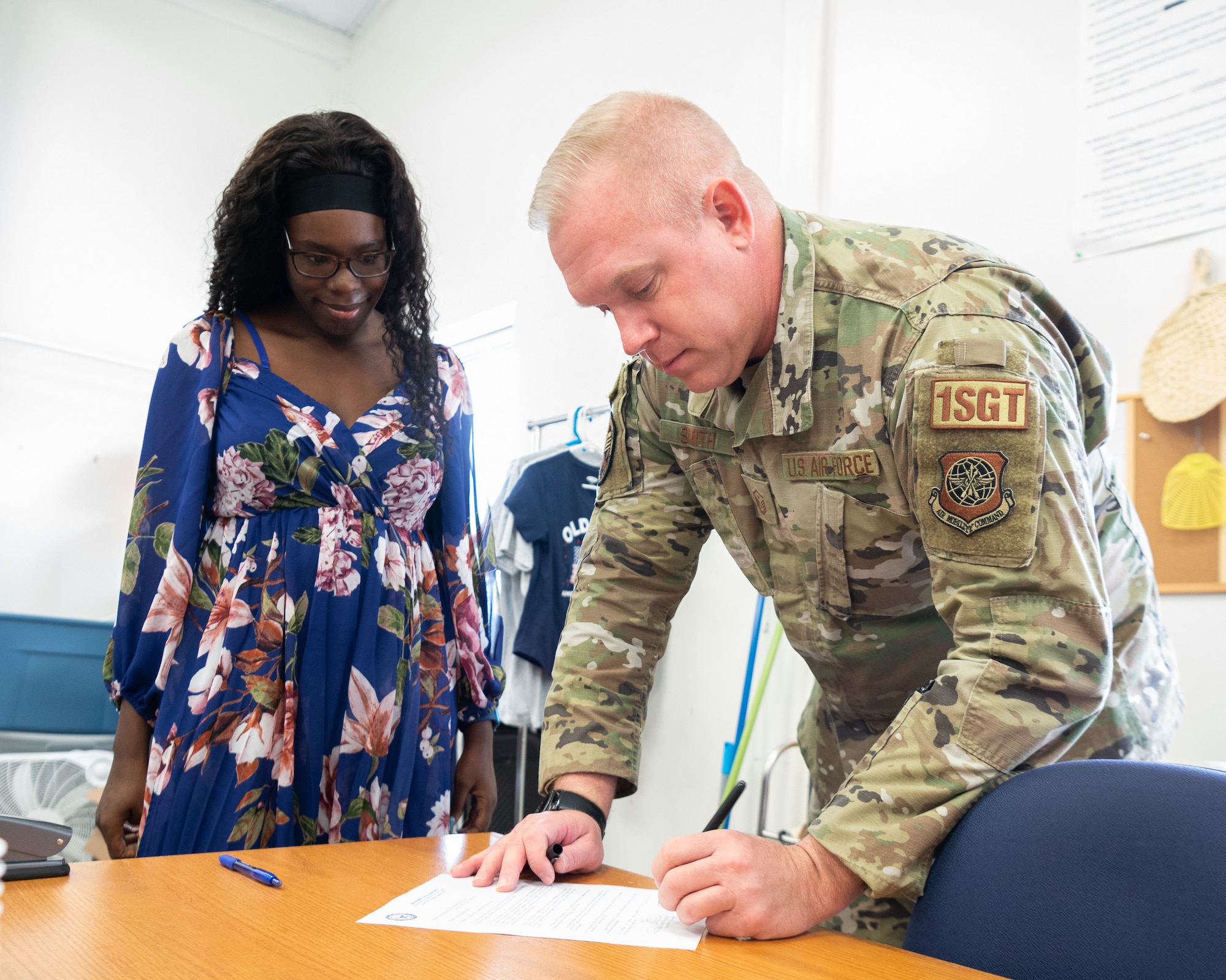 Master Sgt. Jason Smith, right, 436th Aerial Port Squadron first sergeant, relinquishes control of the Airman’s Attic to Casey Hill, president of the Dover Spouses Club, at Dover Air Force Base, Delaware, March 23, 2022. The Dover Spouses club will now oversee all operations at the Airman’s Attic which offers Team Dover Airmen and their families free household items, food and uniforms. (U.S. Air Force photo by Mauricio Campino)