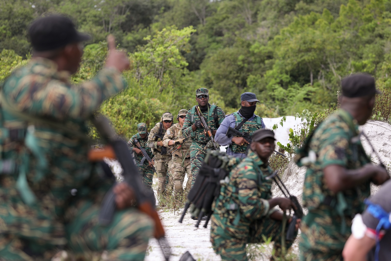 Guyana Defense Force (GDF) personnel and Florida Army National Guard Soldiers with B/2-54th Security Force Assistance Brigade (SFAB) assess security tactics during a knowledge exchange at Base Camp Stephenson, Guyana, March 22, 2022. Guyana and the Florida Guard have been partners under the National Guard Bureau's State Partnership Program since 2003.