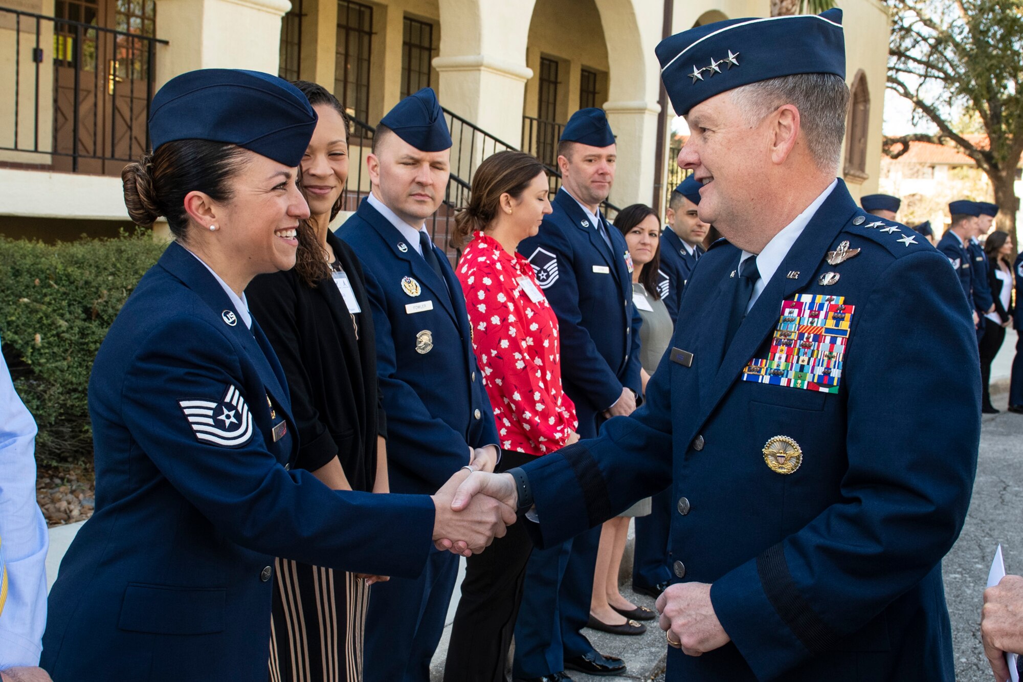 Tech Sgt. Rebecca Absher (left) a recruiting and retention noncommissioned officer from the 140th Wing, Colorado Air National Guard, shakes hands with Lt. Gen. Brad Webb, commander of Air Education and Training Command March 9, 2022, outside of the AETC headquarters at Joint Base San Antonio-Randolph, Texas.