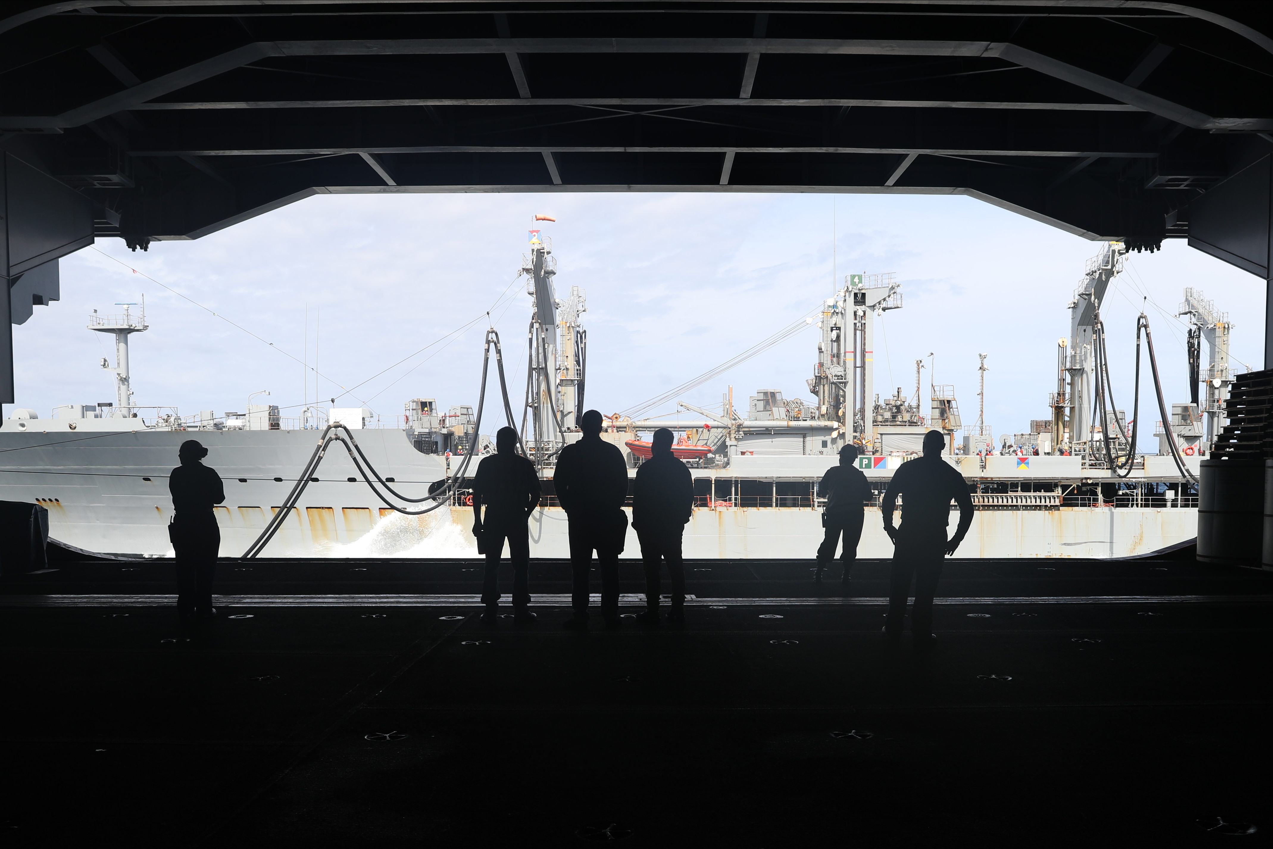 Sailors watch from the hangar bay of the aircraft carrier  USS Gerald R. Ford (CVN 78) during a fueling at sea with the Military Sealift Command fleet replenishment oiler USNS Kanawha (T-AO 196).