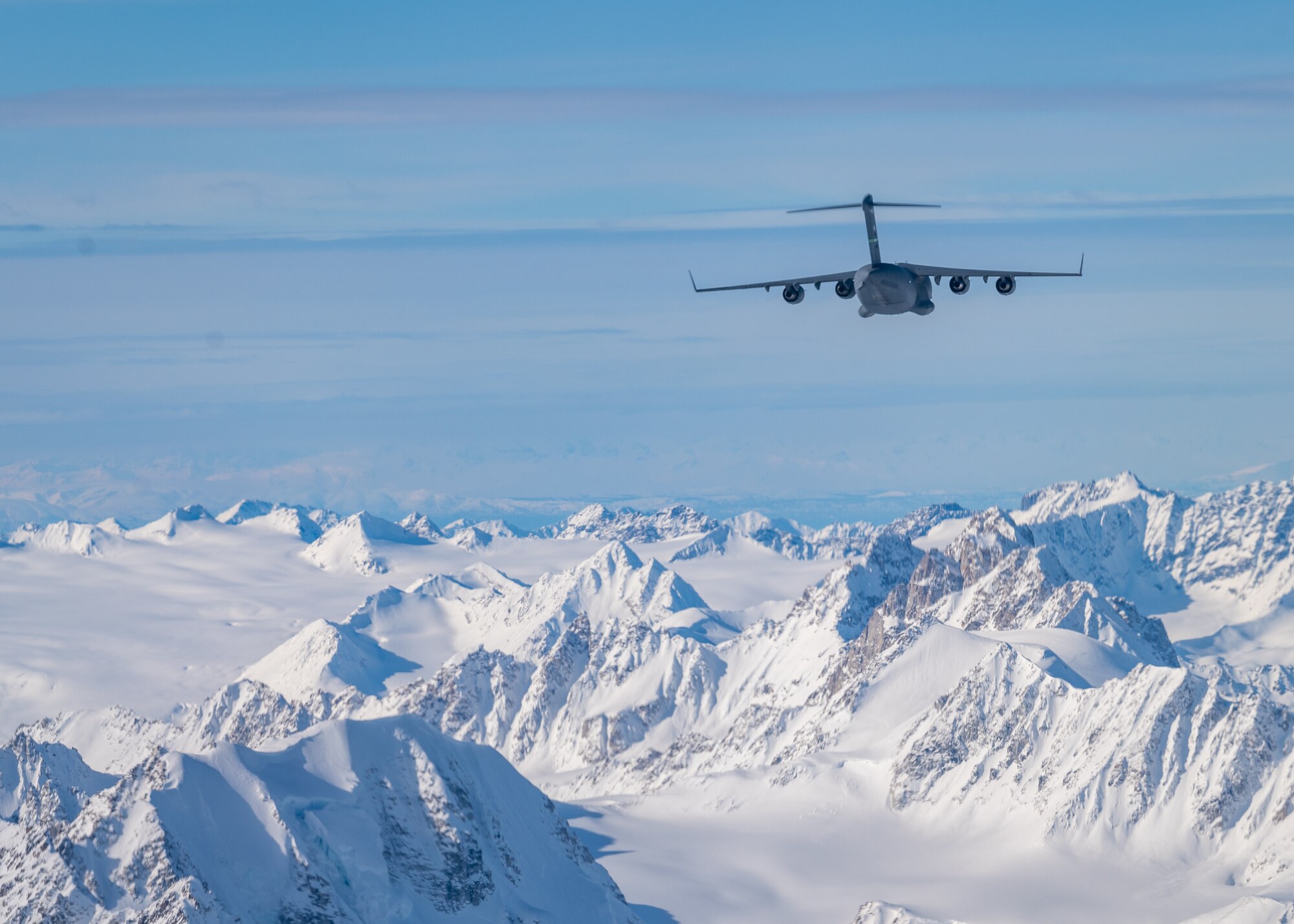 A U.S. Air Force C-17 Globemaster III assigned to Joint Base Lewis-McChord flies over the Alaska Range, Alaska, March 21, 2022, during Exercise Rainer War 22-A. The exercise is designed to demonstrate the 62nd Airlift wing’s ability to operate and survive while defeating challenges to the U.S. military advantage in all operating domains – air, land, sea and cyberspace. (U.S. Air Force photo by Airman 1st Class Charles Casner)