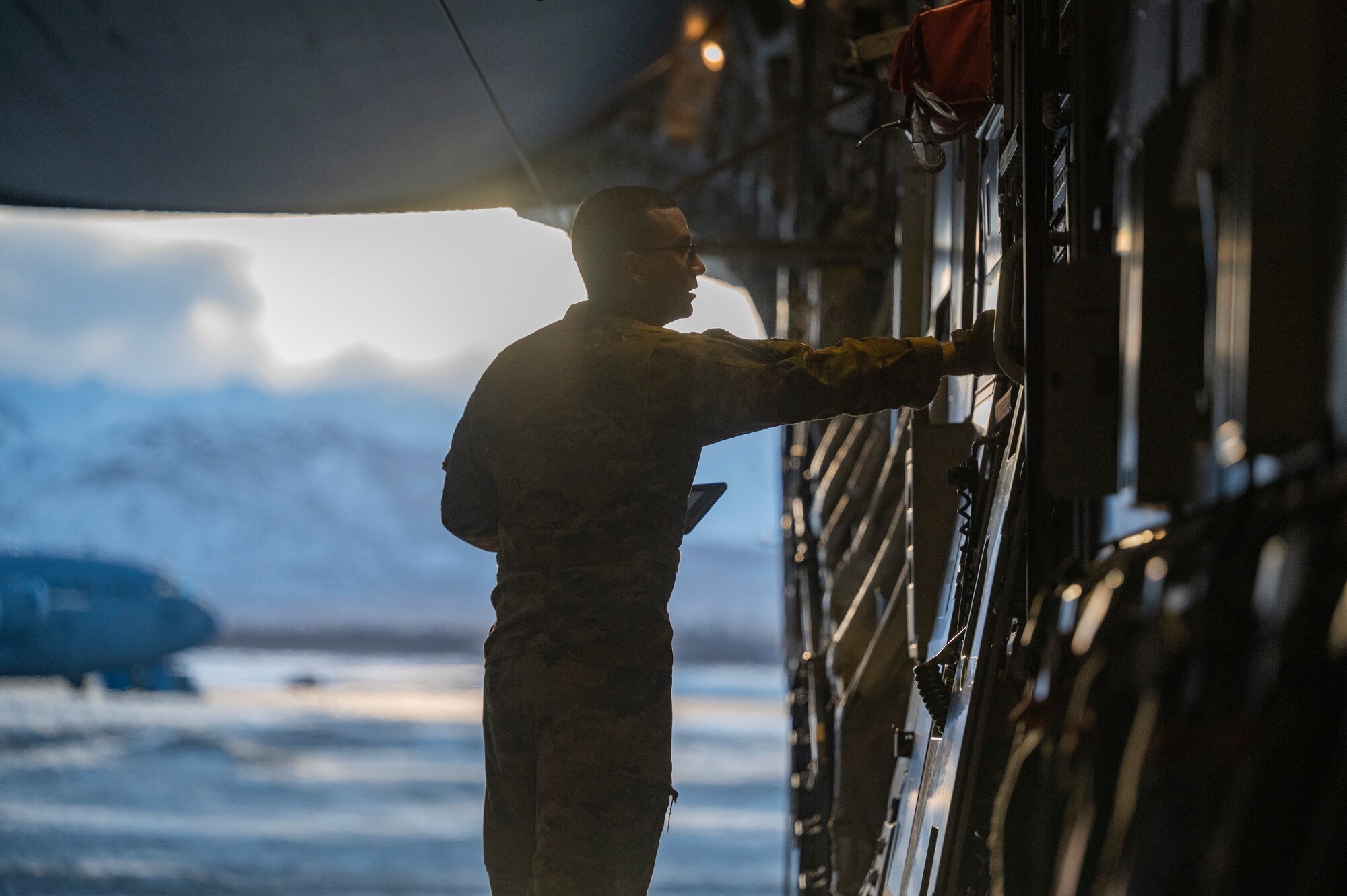 U.S. Air Force Tech. Sgt.  Liam Vining, a loadmaster assigned to the 8th Airlift Squadron, opens the bay door of a C-17 Globemaster III assigned to Joint Base Lewis-McChord, Washington, during Exercise Rainer War 22A at Joint Base Elmendorf-Richardson, Alaska, March 23, 2022. The exercise is designed to demonstrate the 62nd Airlift Wing’s ability to operate and survive while defeating challenges to the U.S. military advantage in all operating domains – air, land, sea and cyberspace. (U.S. Air Force photo by Airman 1st Class Charles Casner)