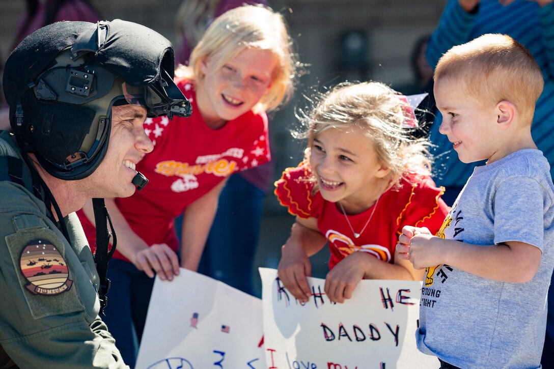 A Marine smiles as he looks at his children.