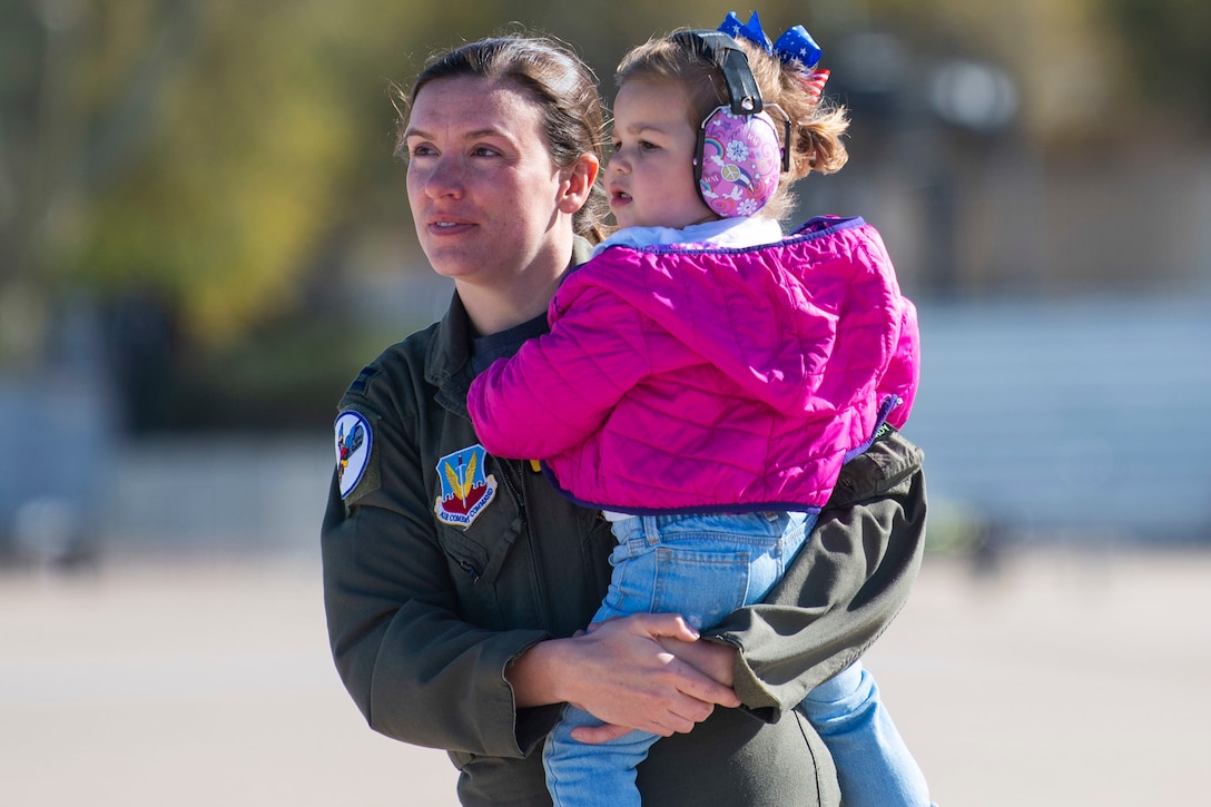 An airman holds her child.