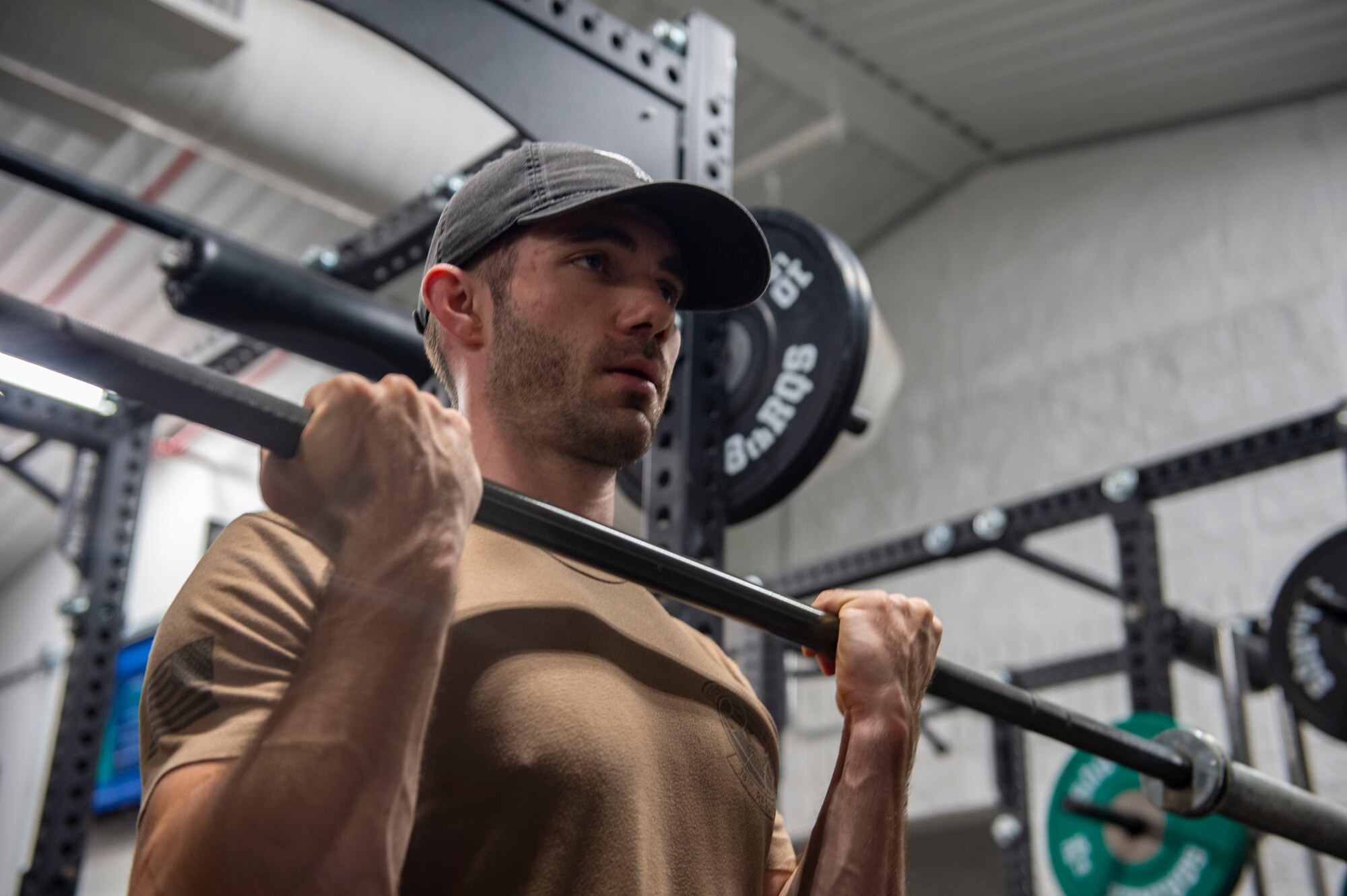 A photo of a man holding a bar, working out.