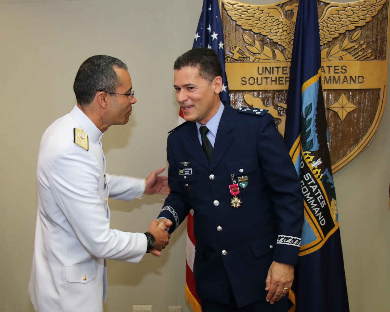 Brazilian Lt. Gen. David Alcoforado shakes hands with Brazilian Rear Adm. José Achilles A. J. Teixeira during an awards ceremony.