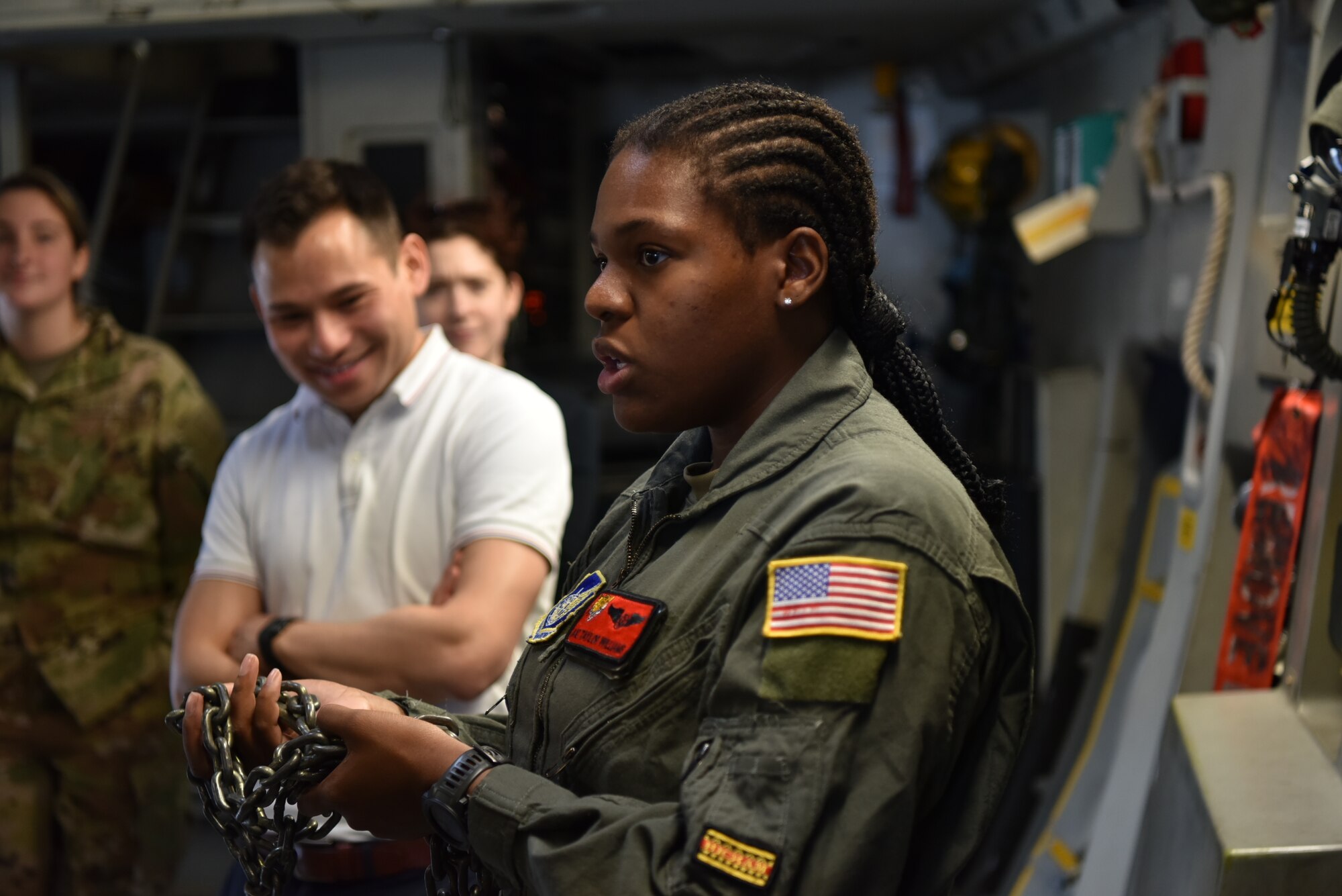 Airman First Class Taylor Williams, 535th Airlift Squadron loadmaster, briefs students from the Massachusetts Institute of Technology Security Studies Program about equipment used on board a C-17 Globemaster III to secure cargo at Joint Base Pearl Harbor-Hickam, Hawaii, March 23, 2022. The MIT Security Studies Programs accepts one serving member of the United States Air Force, Navy and Marine Corps, and two serving members of the Army to participate in classes. (U.S. Air Force photo by 1st Lt. Benjamin Aronson)