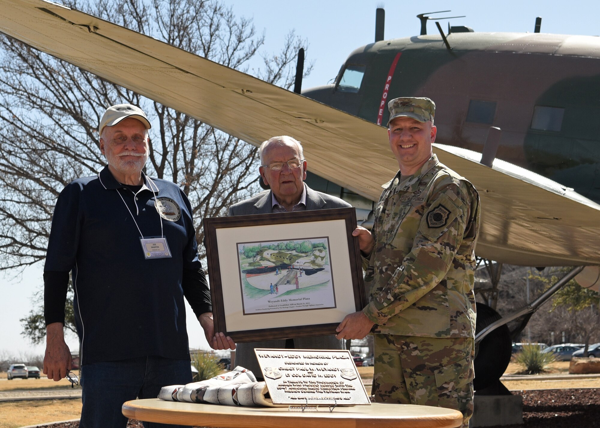 r. Joe Martin, U.S. Air Force veteran, Bill Francis, retired U.S. Air Force chief master sergeant, and Col. Matthew Reilman, 17th Training Wing commander, hold a picture, dedicating the Weyandt-Eddy Memorial Plaza at Goodfellow Air Force Base, Texas, March 25, 2022. The dedication supported the intent of the 17th TRW Heritage Campaign Plan, the 17 TRW Historian Strategic Plan, and the 17 TRW Strategic Plan. (U.S. Air Force photo by Senior Airman Abbey Rieves)