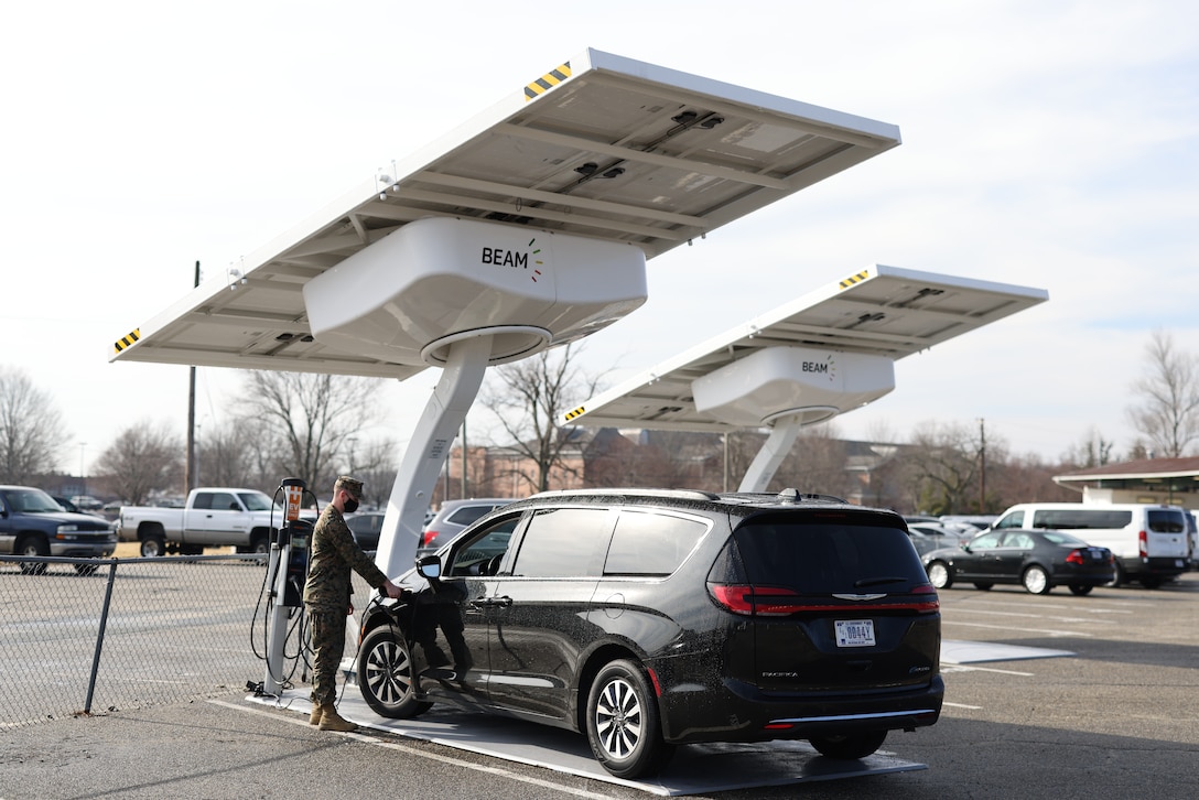 A Marine driver for Marine Corps Base (MCB) Quantico, charges one of the government fleet vehicles with the Beam EV ARC 2020 electric vehicle chargers.