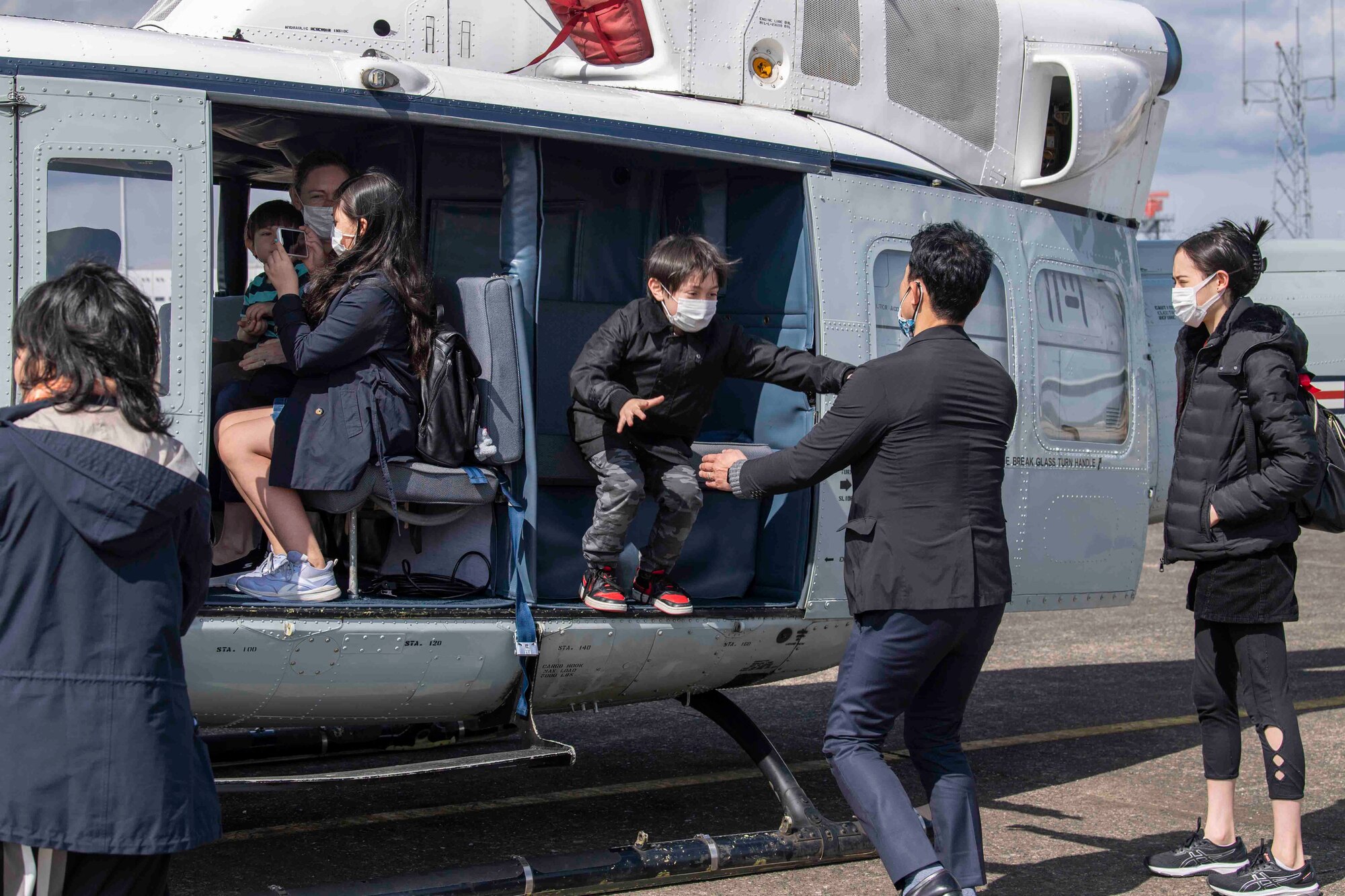 A child jumps from a static display UH-1N assigned to the 459th Airlift Squadron during a community outreach tour at Yokota Air Base, Japan, March 19, 2022.