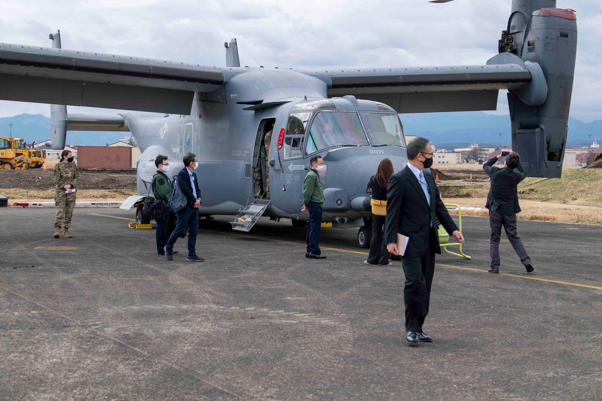 Visiting Japanese leaders observe a CV-22 Osprey static display during a community outreach tour at Yokota Air Base, Japan, March 19, 2022.