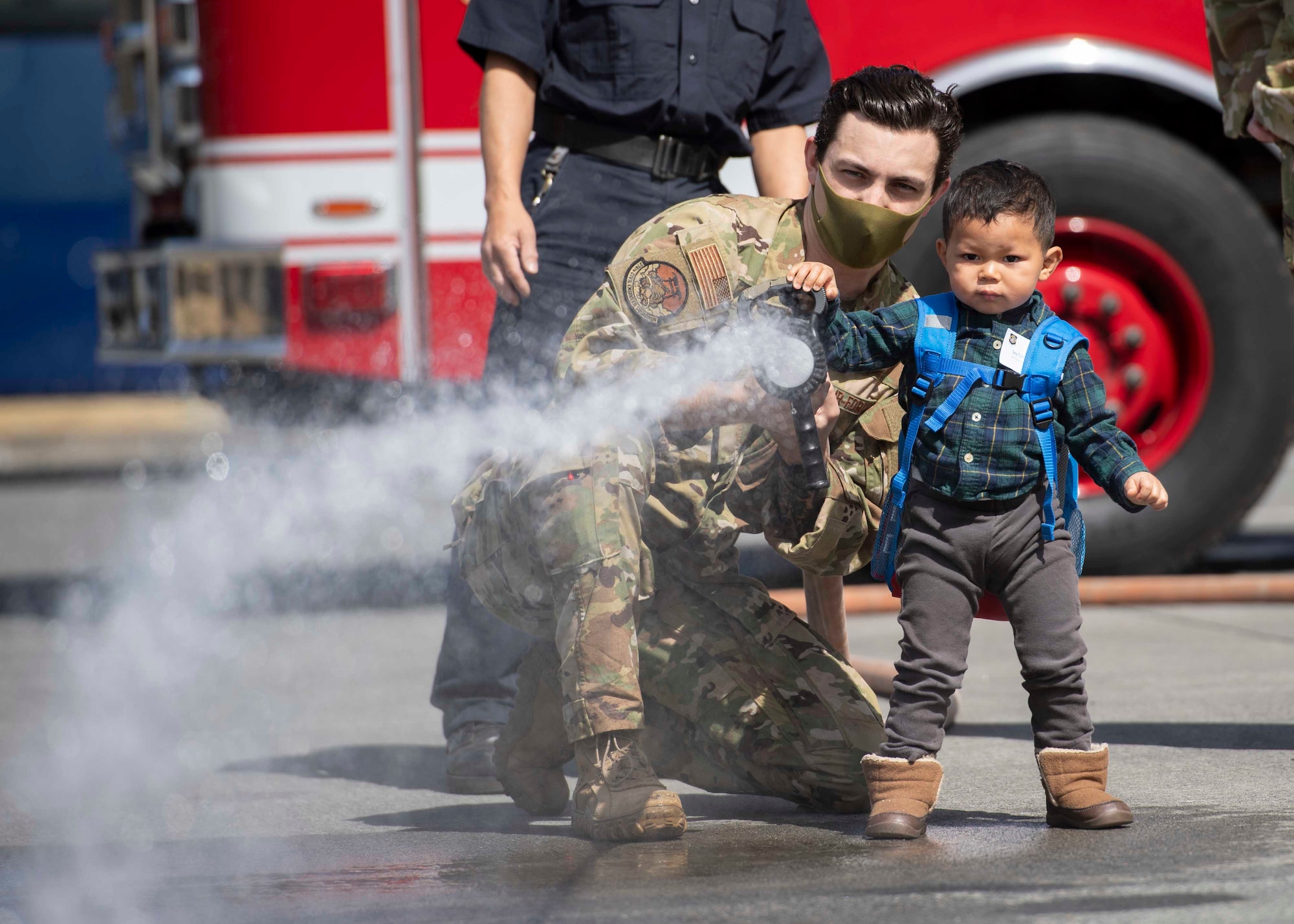Staff Sgt. Alex Rowe, 374th Civil Engineer Squadron firefighter, demonstrates how to use a fire hose during a community outreach tour at Yokota Air Base, Japan, Mar. 19, 2022.