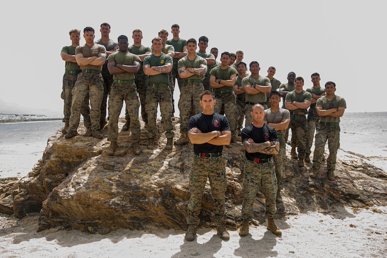 U.S. Marines with 2nd Battalion, 7th Marine Regiment, 1st Marine Division, pose for a group photo after the culminating event of a Martial Arts Instructor course on Camp Schwab, Okinawa, Japan, March 17, 2022. Marines endured the three-week long Marine Corps Martial Arts Instructor course that entailed hand-to-hand combat, warrior ethos instruction, grappling, and weapons sparring training with the goal of graduating as a Marine Corps Martial Arts Instructor. The MAI course certifies Marines to train and test other Marines in various belt levels of the Marine Corps Martial Arts Program. (U.S. Marine Corps photo by Cpl. Alex Fairchild)