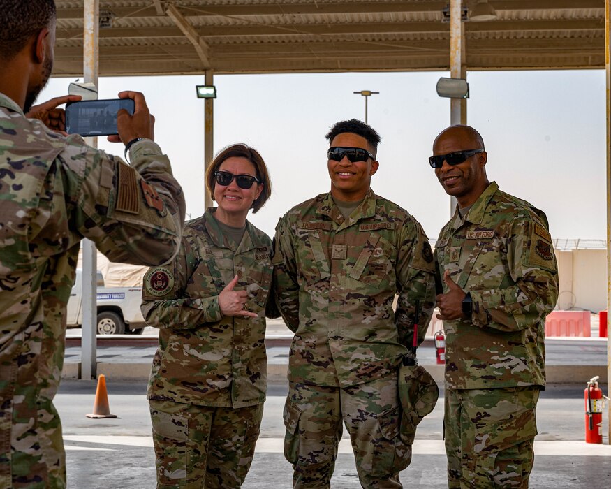 Chief Master Sgt. of the Air Force JoAnne S. Bass and Chief Master Sgt. Mike Perry, Air Force first sergeant special duty manager, pose with Airman 1st Class Jordan Thompson, 380th Expeditionary Logistics Readiness Squadron member, at Al Dhafra Air Base, United Arab Emirates, March 24, 2022.