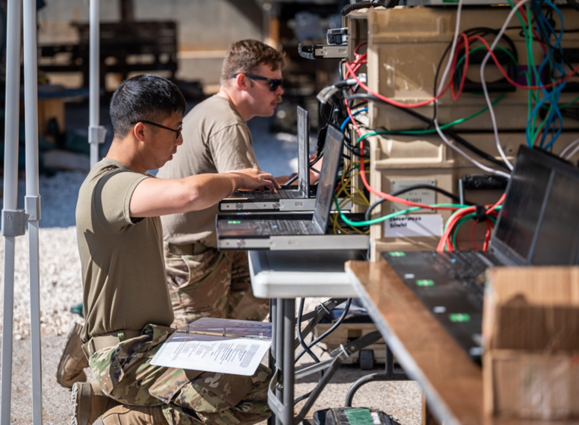 Airman First Class Bee Yang and Staff Sgt. Steven Henderson, 332d Expeditionary Communications Squadron network management technicians, complete pre-deployment inspections on network computers at an undisclosed location in Southwest Asia, March 14, 2022. The 332d ECS provides a broad range of communication services to the 332d AEW workforce to win the fight today as well as tomorrow - building on the Red Tail legacy of excellence. (U.S. Air Force photo by Master Sgt. Christopher Parr)