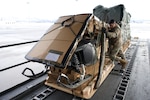 Alaska Air National Guard Master Sgt. Santiago Maya, 176th Logistics Readiness Squadron Air Transportation Function operations superintendent, loads a snowmachine into a 144th Airlift Squadron C-17 Globemaster III Feb. 23, 2022, at Joint Base Elmendorf-Richardson. The snowmachine is part of equipment used on the North Pole sea ice in support of U.S. Navy personnel as part of Ice Exercise 2022.