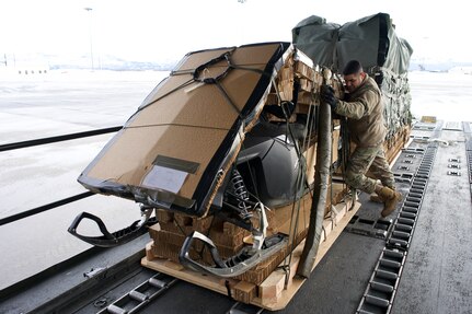 Alaska Air National Guard Master Sgt. Santiago Maya, 176th Logistics Readiness Squadron Air Transportation Function operations superintendent, loads a snowmachine into a 144th Airlift Squadron C-17 Globemaster III Feb. 23, 2022, at Joint Base Elmendorf-Richardson. The snowmachine is part of equipment used on the North Pole sea ice in support of U.S. Navy personnel as part of Ice Exercise 2022.