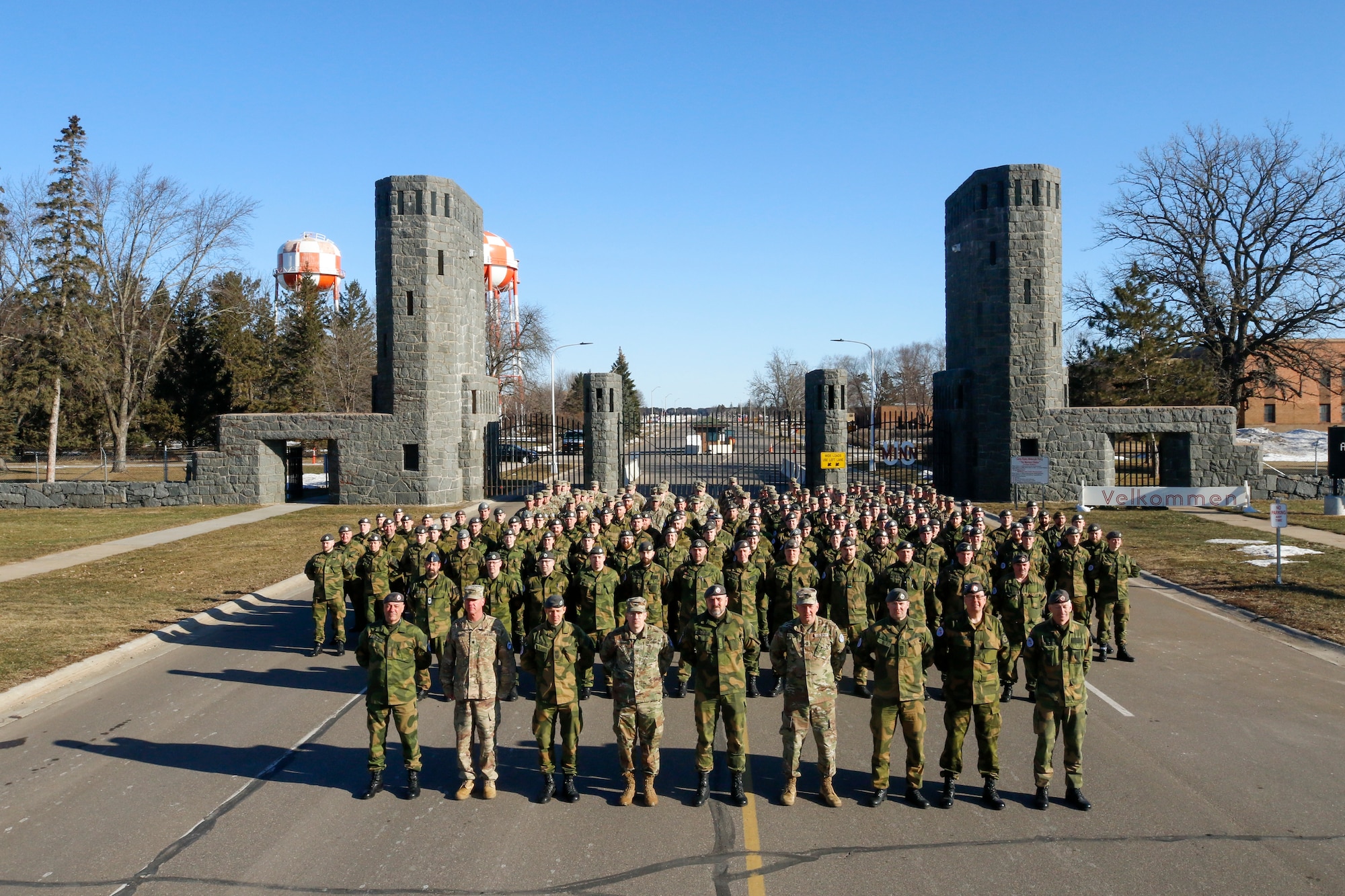 Minnesota National Guard Soldiers and service members from the Norwegian military’s Home Guard in front of the main gate at Camp Ripley, Minnesota, March 26, 2022, after the start of the the 49th Annual Norwegian Exchange. The partnership develops relationships between international allies through training exercises in Minnesota and Norway.