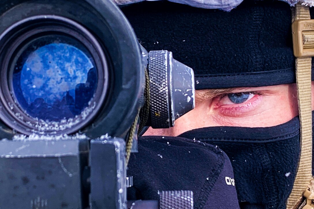 A soldier aims his machine gun.