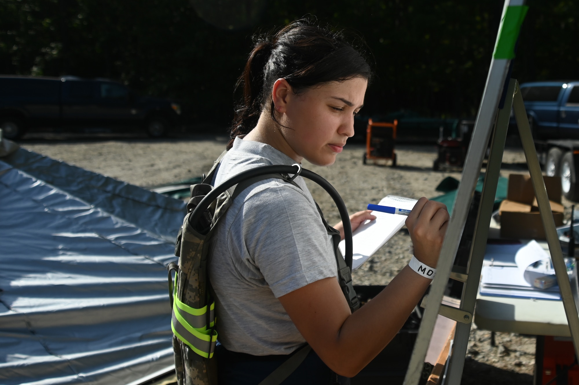 U.S. Air Force Airman 1st Class Destiny Melendez, 113th Fatality Search and Recovery Team Tactical Operations Center, D.C. Air National Guard, writes on a board during the Chemical Biological Radiological Nuclear Emergency Response Force Package pre-evaluation and training at the Fort Pickett Maneuver Training Center in Blackstone, Virginia, Aug. 27, 2021. (U.S. Air National Guard photo by Airman 1st Class Daira Jackson)
