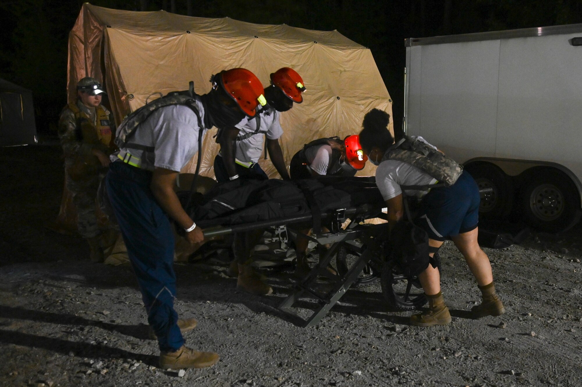 National Guardsmen assigned to the 113th Fatality Search and Recovery Team, D.C. Air National Guard, lower a gurney during the Chemical Biological Radiological Nuclear Emergency Response Force Package pre-evaluation and training at the Fort Pickett Maneuver Training Center in Blackstone, Virginia, Aug. 27, 2021. (U.S. Air National Guard photo by Airman 1st Class Daira Jackson)