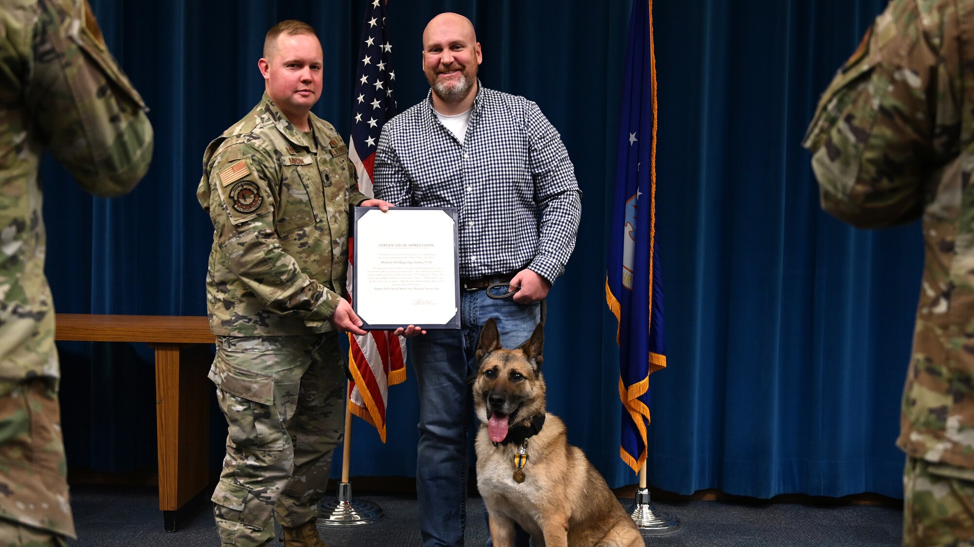A man and dog accept a certificate.
