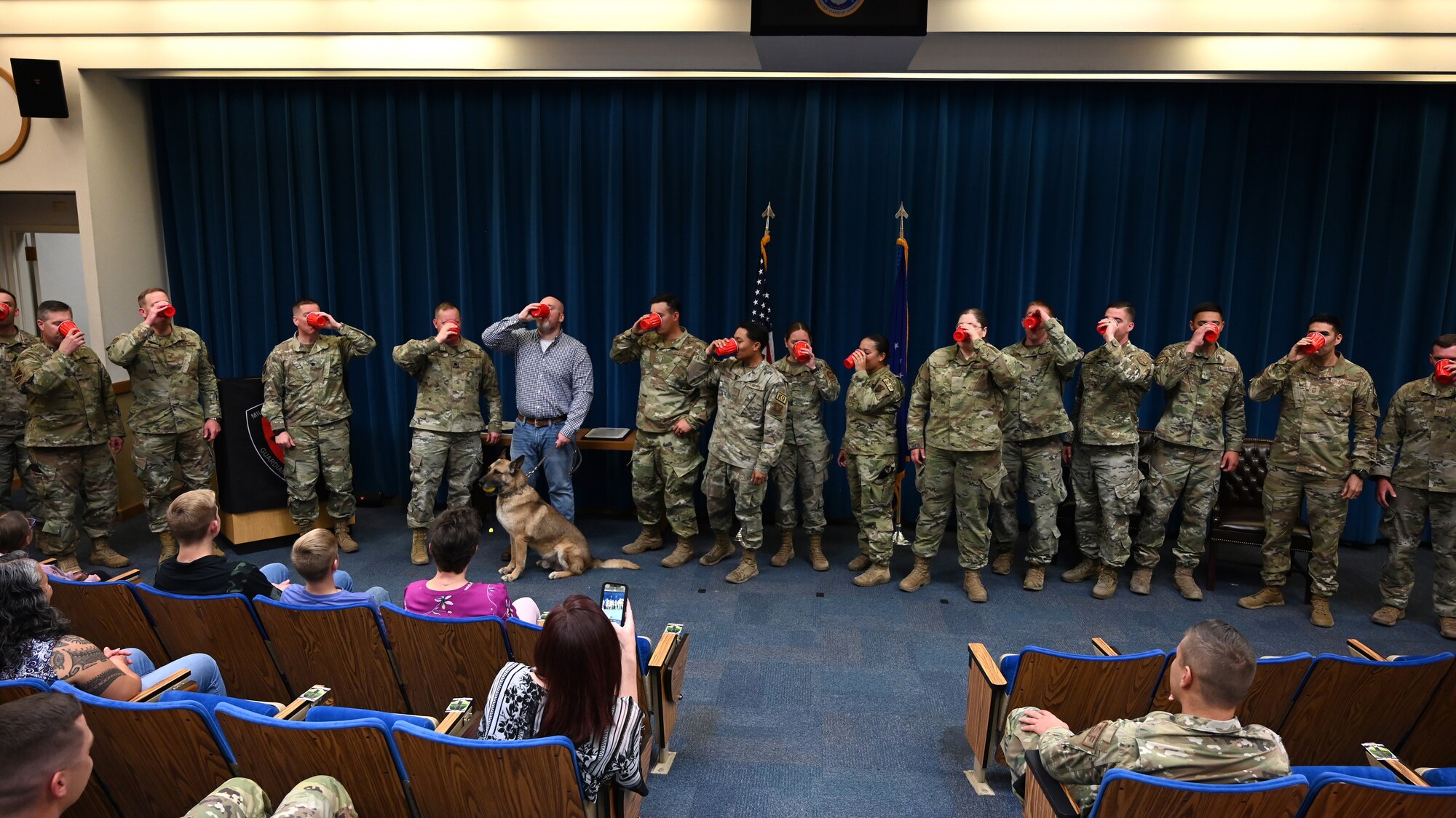 A group of Airmen drink from cups together.