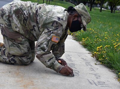 Staff Sgt. Ella Greene, victim advocate for U.S. Army Medical Logistics Command, participates in the "Chalk the Walk" event during AMLC's 2021 campaign in support of Sexual Assault Awareness and Prevention Month. The command is hosting the same event during April 2022, along with several more in participation with this year's observance.