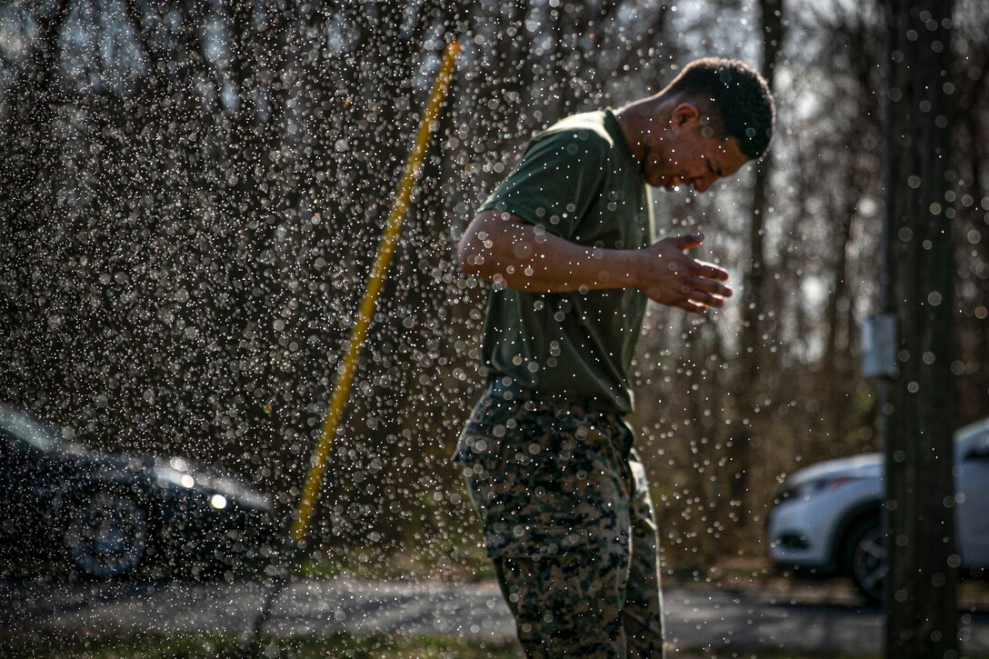 A Marine gets sprayed with a chemical.