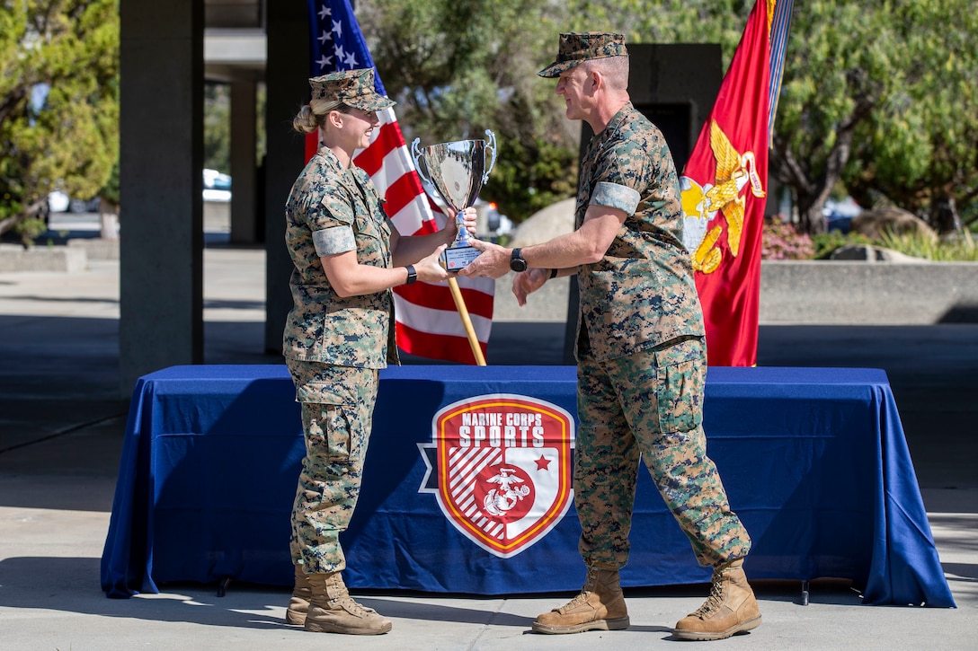 U.S. Marine Brig. Gen. Jason Woodworth, the commanding general of Marine Corps Installations West, Marine Corps Base Camp Pendleton, presents 1st Lt. Riley Compton, the logistics officer with Marine Aviation Logistics Squadron 39, Marine Aircraft Group 39, 3rd Marine Aircraft Wing, with the Camp Pendleton Female Marine Athlete of the Year award during a ceremony on Camp Pendleton, California, March 18, 2022. Compton received this honor after being nominated by her command for her various physical achievements in 2021, including becoming a developmental bobsled pilot for Team USA. Woodworth is a native of Suffield, Connecticut. Compton is a native of Carmel, Indiana. (U.S. Marine Corps photo by Cpl. Alison Dostie)