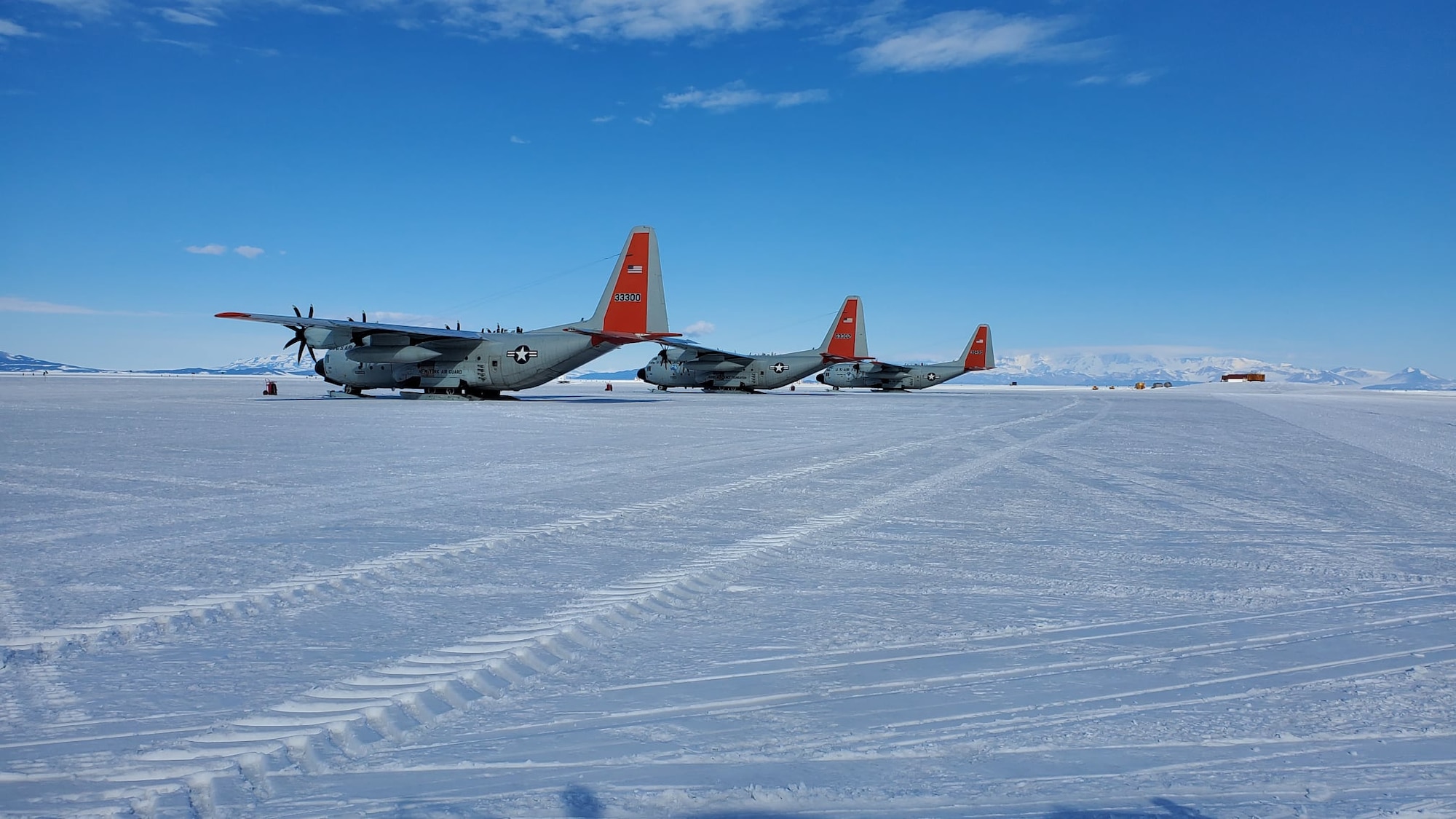 Three LC-130 aircraft sit on the flightline during Operation Deep Freeze at McMurdo Research Station (Williams Field), Antarctica, in 2021.