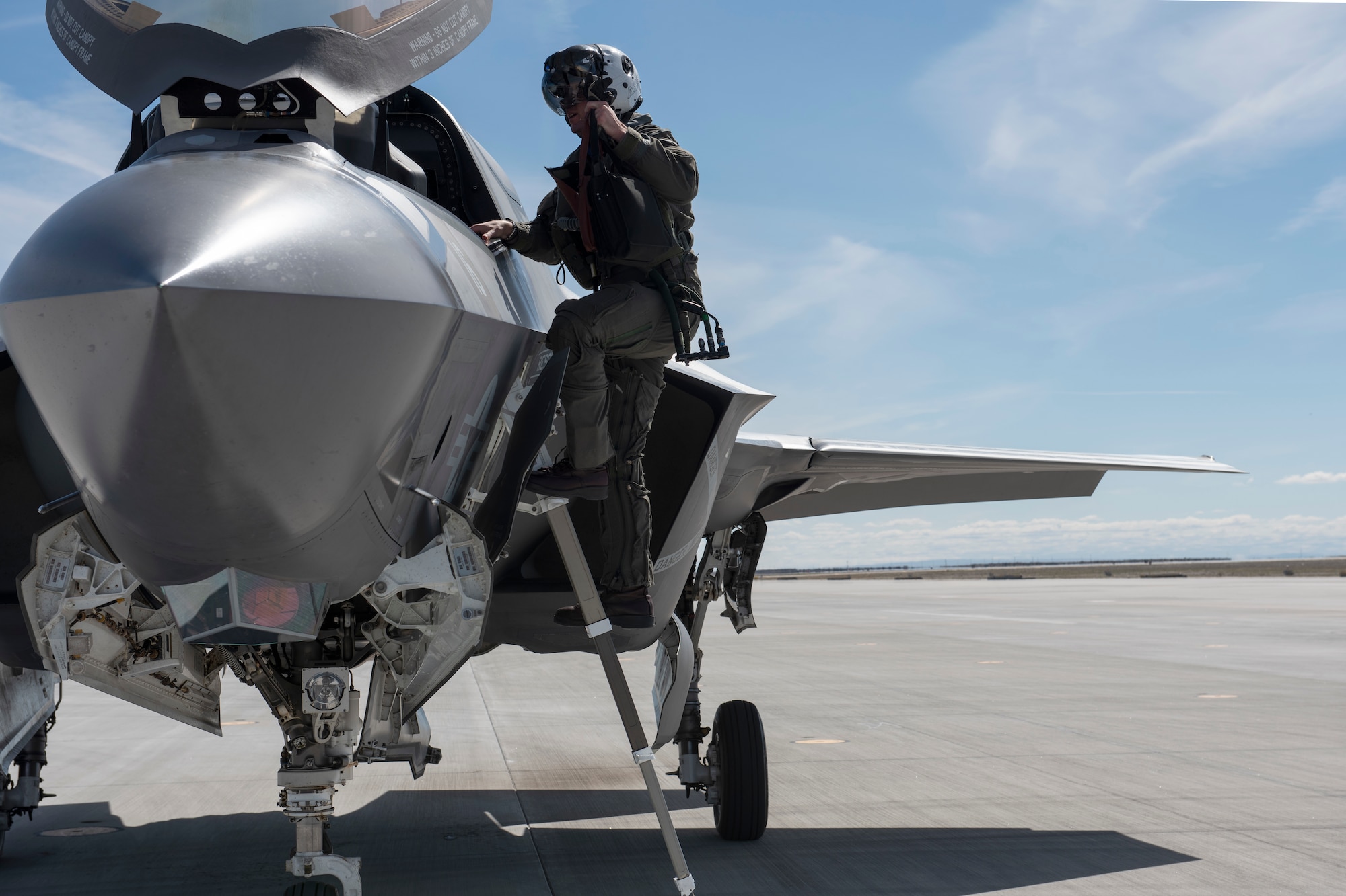 A Marine Corps pilot climbs on a F-35B Lightning II fighter jet.