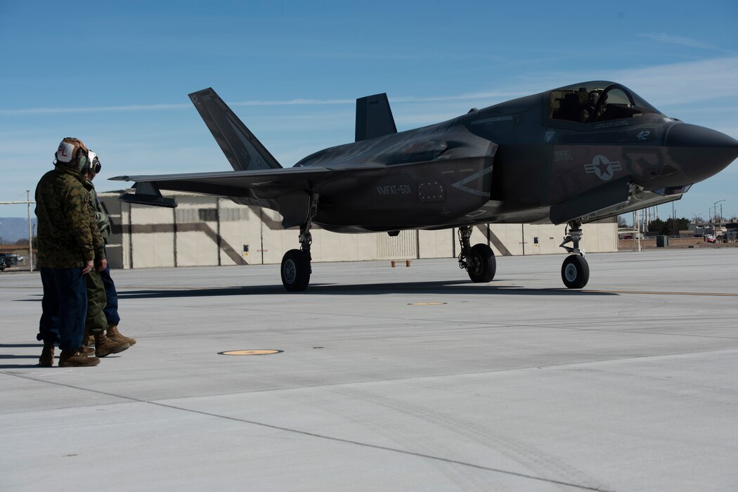 Marines watch a F-35B Lightning II fighter jet taxi on the flight line.