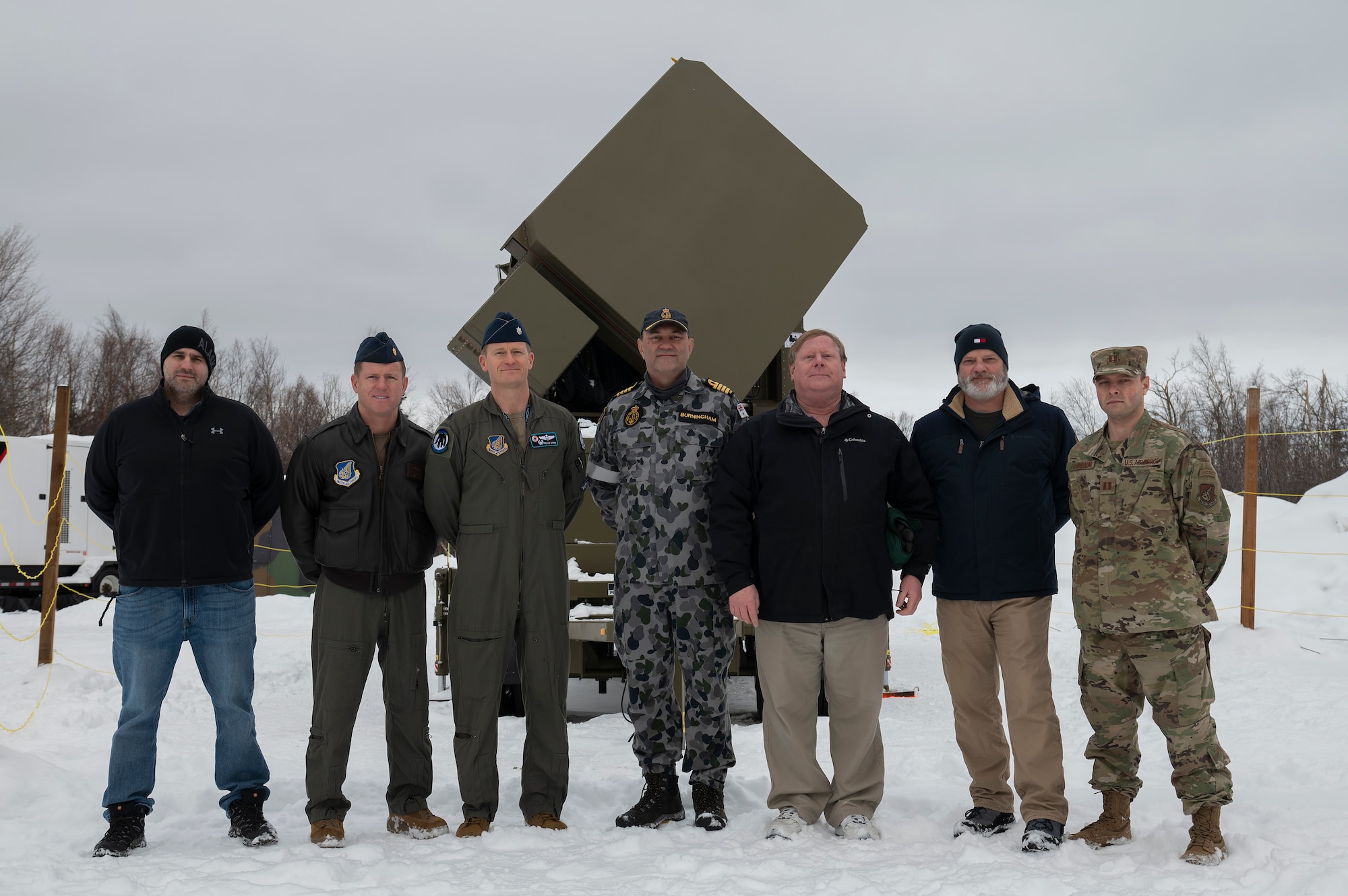 U.S. Airmen assigned to the 354th Range Squadron and representatives from the Royal Australian Navy pose in front of the Joint Pacific Alaska Range Complex’s first advanced emitter near Eielson Air Force Base, Alaska, March 1, 2022.