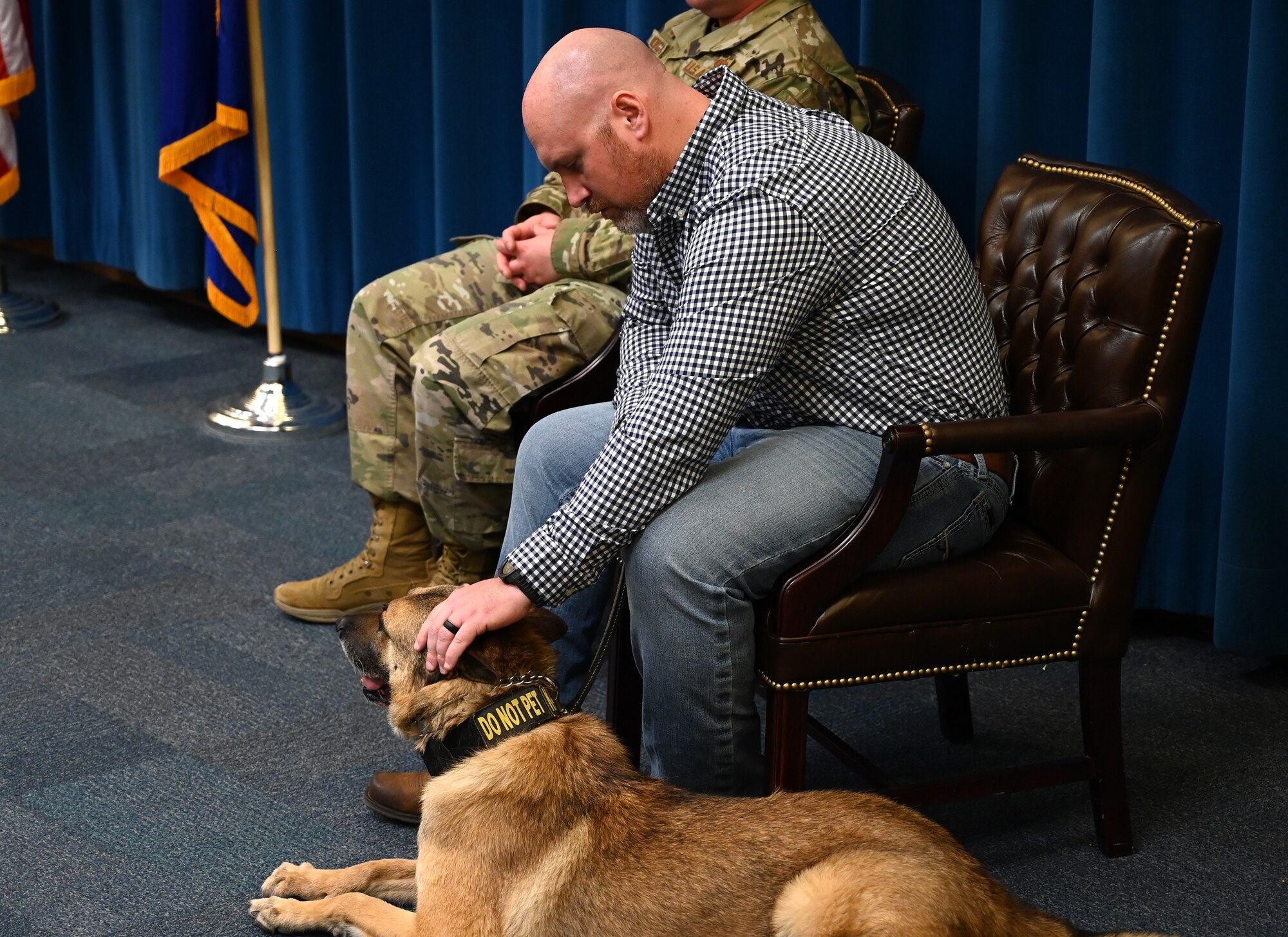 A man pets a dog.