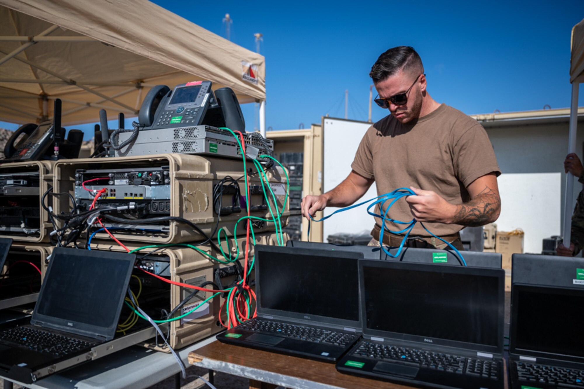 Staff Sgt. Benjamin Wilson, 332d Expeditionary Communications Squadron network infrastructure supervisor, prepares computers and network systems to test and ensure expeditionary network capabilities at an undisclosed location in Southwest Asia, March 14, 2022. The 332d ECS provides a broad range of communication services to the 332d AEW workforce to win the fight today as well as tomorrow - building on the Red Tail legacy of excellence. (U.S. Air Force photo by Master Sgt. Christopher Parr)