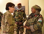 Army 1st Sgt. Marissa Lowe, left, the senior human resources noncommissioned officer with the Kentucky Army National Guard’s 63rd Theater Aviation Brigade, talks with a female Djiboutian officer during a State Partnership Program planning conference at Kempinski Palace, Djibouti City, Djibouti, March 8, 2022.