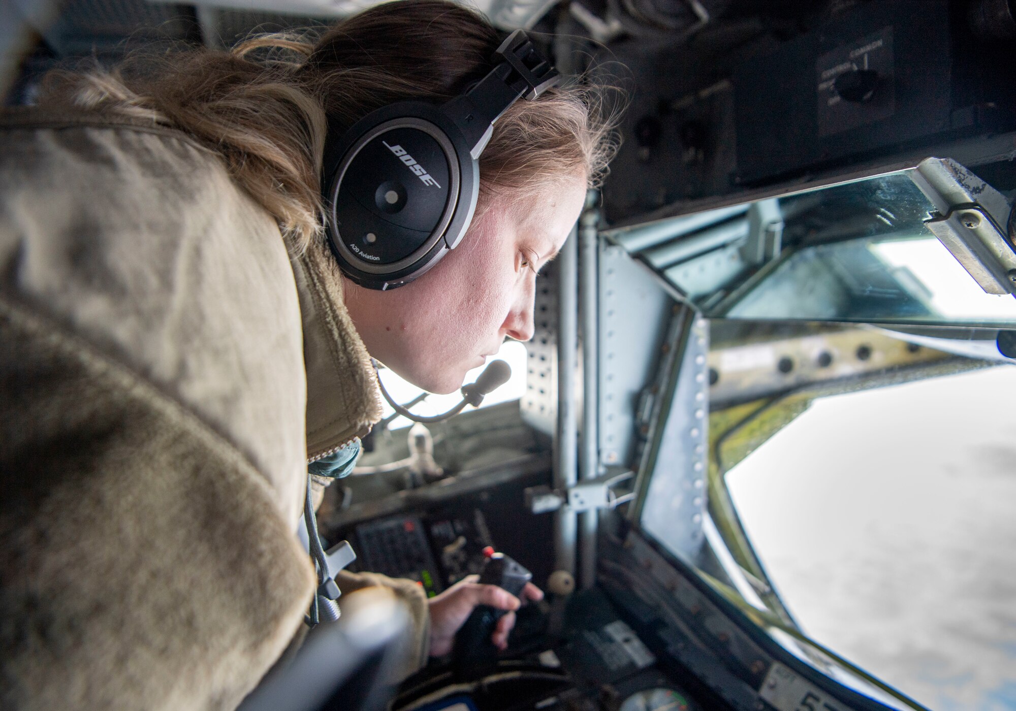 U.S. Air Force Senior Airman Constance Cassens, 92nd Air Refueling Squadron KC-135 boom operator assigned to Fairchild Air Force Base, Washington, prepares for refueling, March 22, 2022. Boom operators are responsible for safely and effectively transferring aviation fuel from one military aircraft to another during flight. (U.S. Air Force photo by Airman 1st Class Jessica Sanchez-Chen)