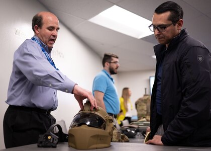 Alex DeGroot, lead systems engineer for helmet protection at Program Executive Office (PEO) Soldier, demonstrates the Next Generation Integrated Helmet Protections System to Sgt. 1st Class Dustin Resendez, Regiment S4 Operations Non-Commissioned Officer in Charge for U.S. Army Special Operations Command (USASOC), during a gear comparison event on Fort Belvoir, March 8. The event provided a familiarization of selected items from Project Manager Soldier Survivability and USASOC’s respective portfolios for a side-by-side comparison, in order to gain knowledge and identify opportunities for collaboration in the future.